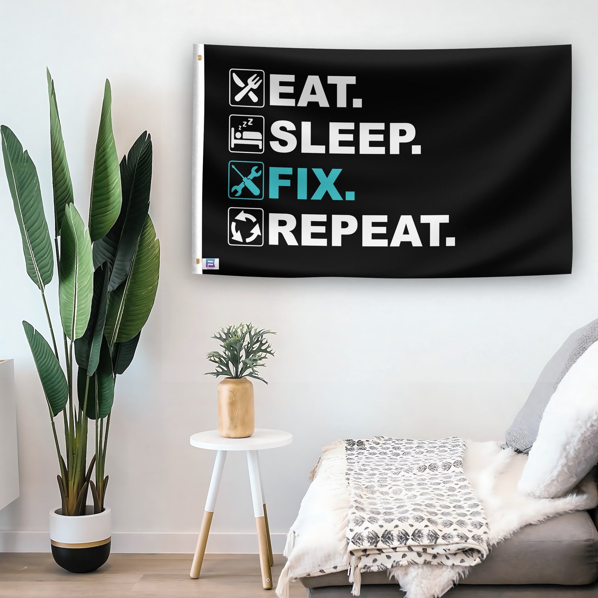 In a home setting, a flag with the saying "Eat Sleep Fix Repeat" is mounted on a white wall by a side table.