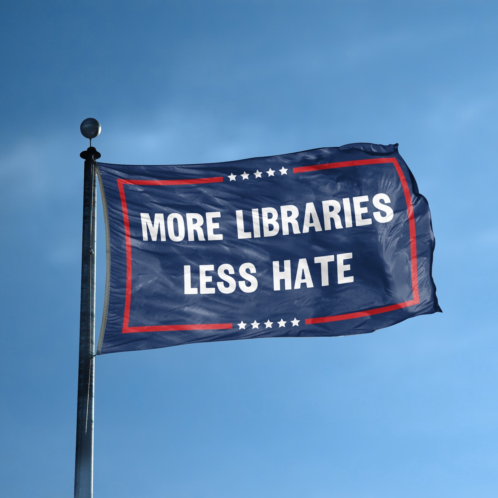 A flag with the saying "More Libraries Less Hate Political" displayed on a high pole, with a red, white, and blue color scheme.