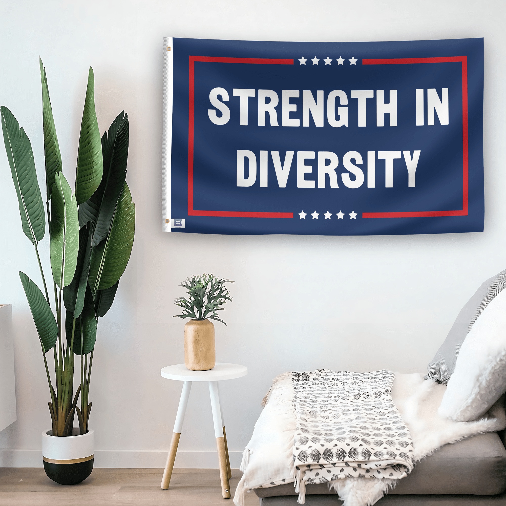 In a home setting, a flag with the saying "Strength In Diversity Political" is mounted on a white wall by a side table.