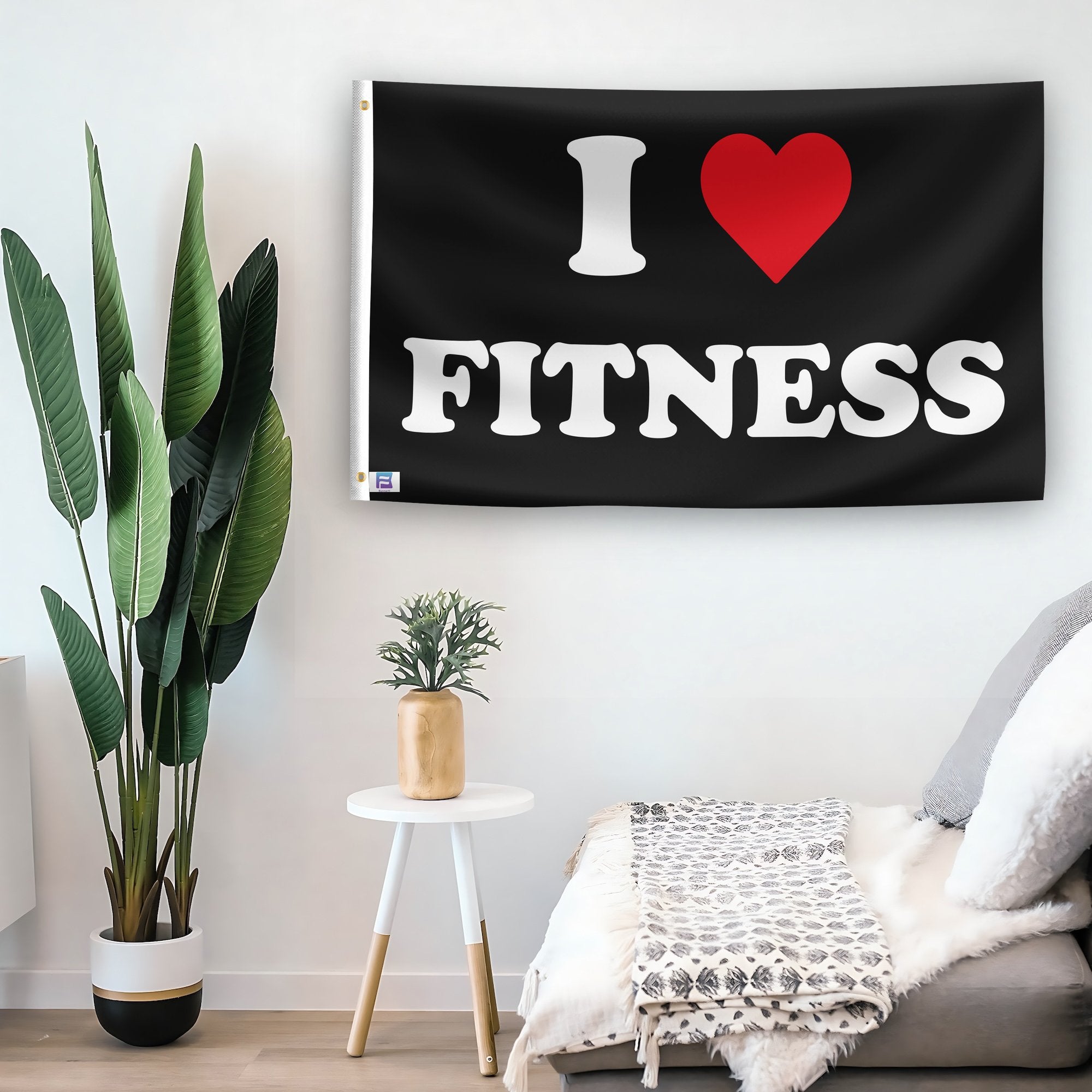 In a home setting, a flag with the saying "I Love Fitness" is mounted on a white wall by a side table.