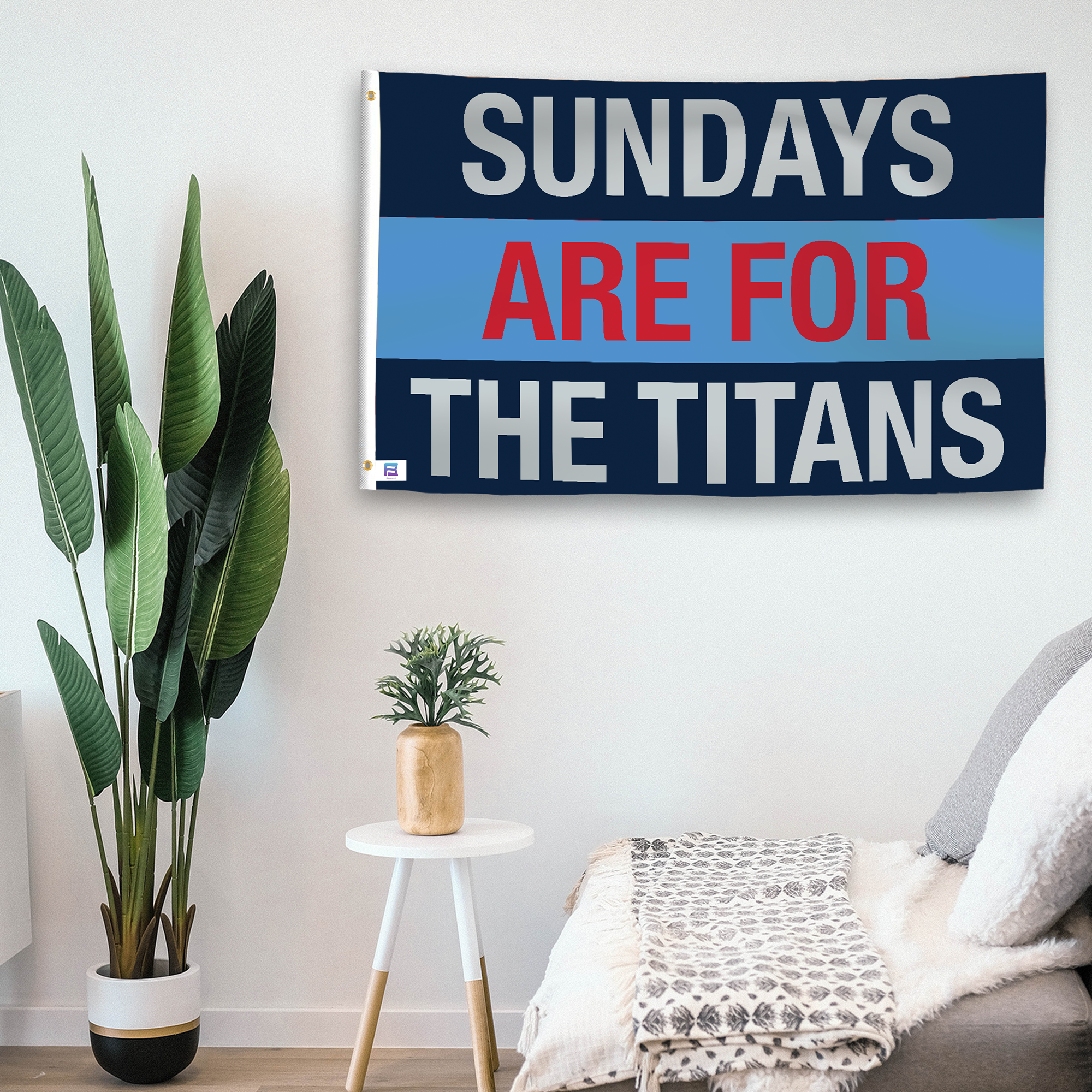 In a home setting, a flag with the saying "https://www.dropbox.com/scl/fi/9gac25k345nptzzg89lyu/sundays-are-for-the-titans_room.png?rlkey=pvztlijyz3po998m039pp5mqt&raw=1" is mounted on a white wall by a side table.