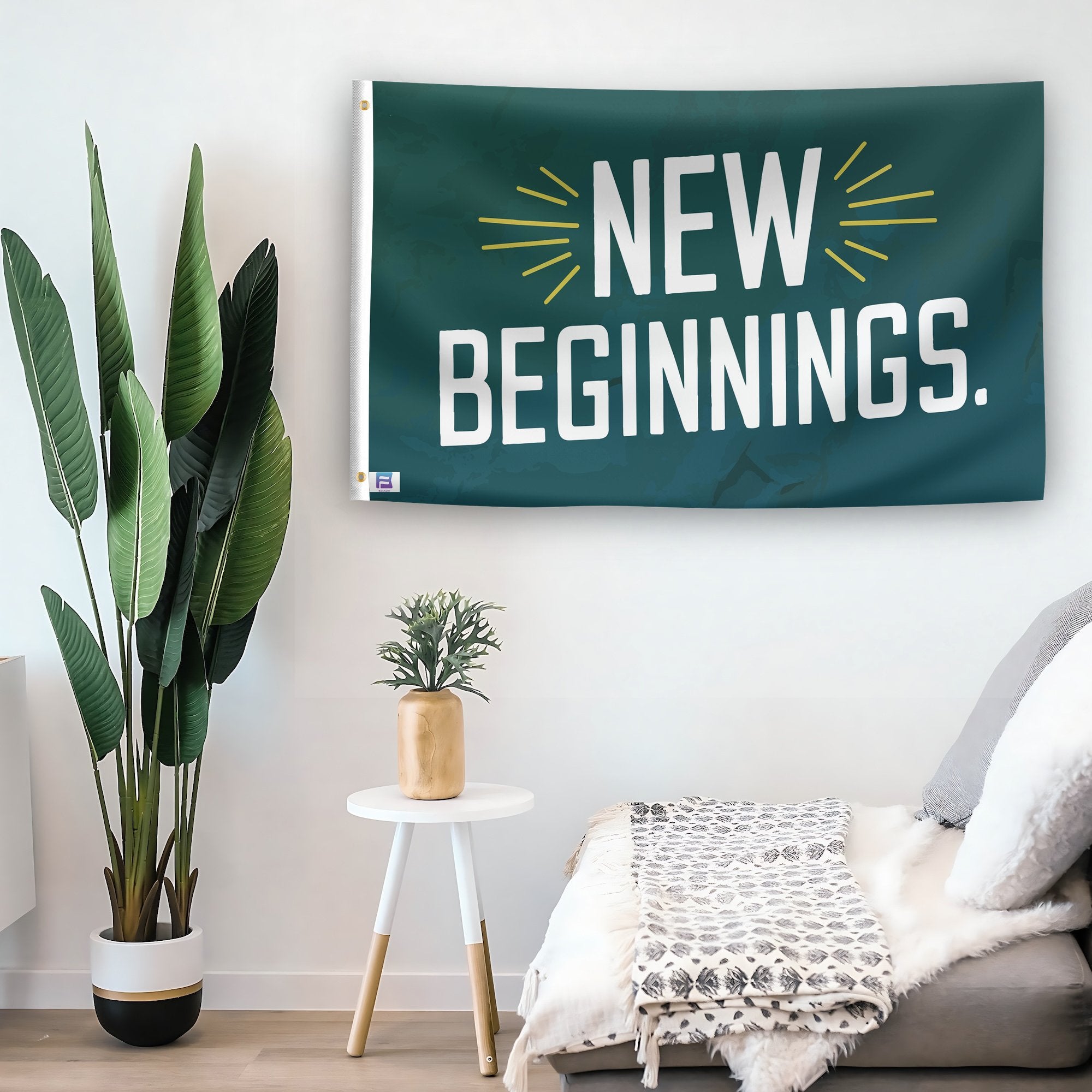 In a home setting, a flag with the saying "New Beginnings" is mounted on a white wall by a side table.