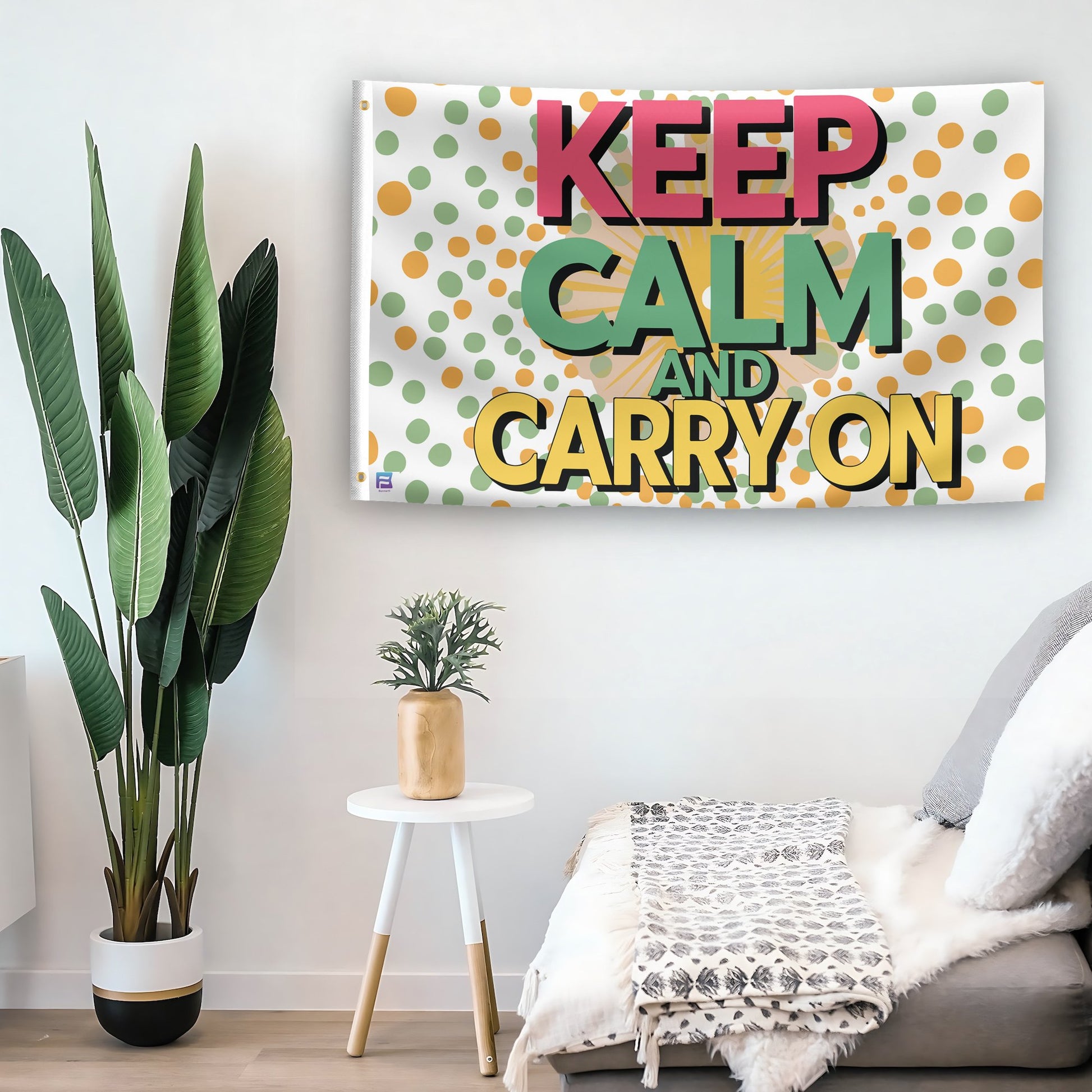 In a home setting, a flag with the saying "Keep Calm And Carry On" is mounted on a white wall by a side table.