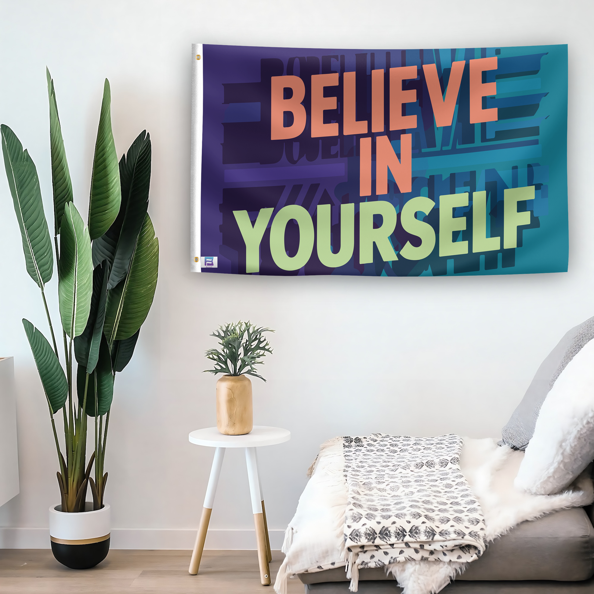 In a home setting, a flag with the saying "Believe In Yourself Motivational" is mounted on a white wall by a side table.