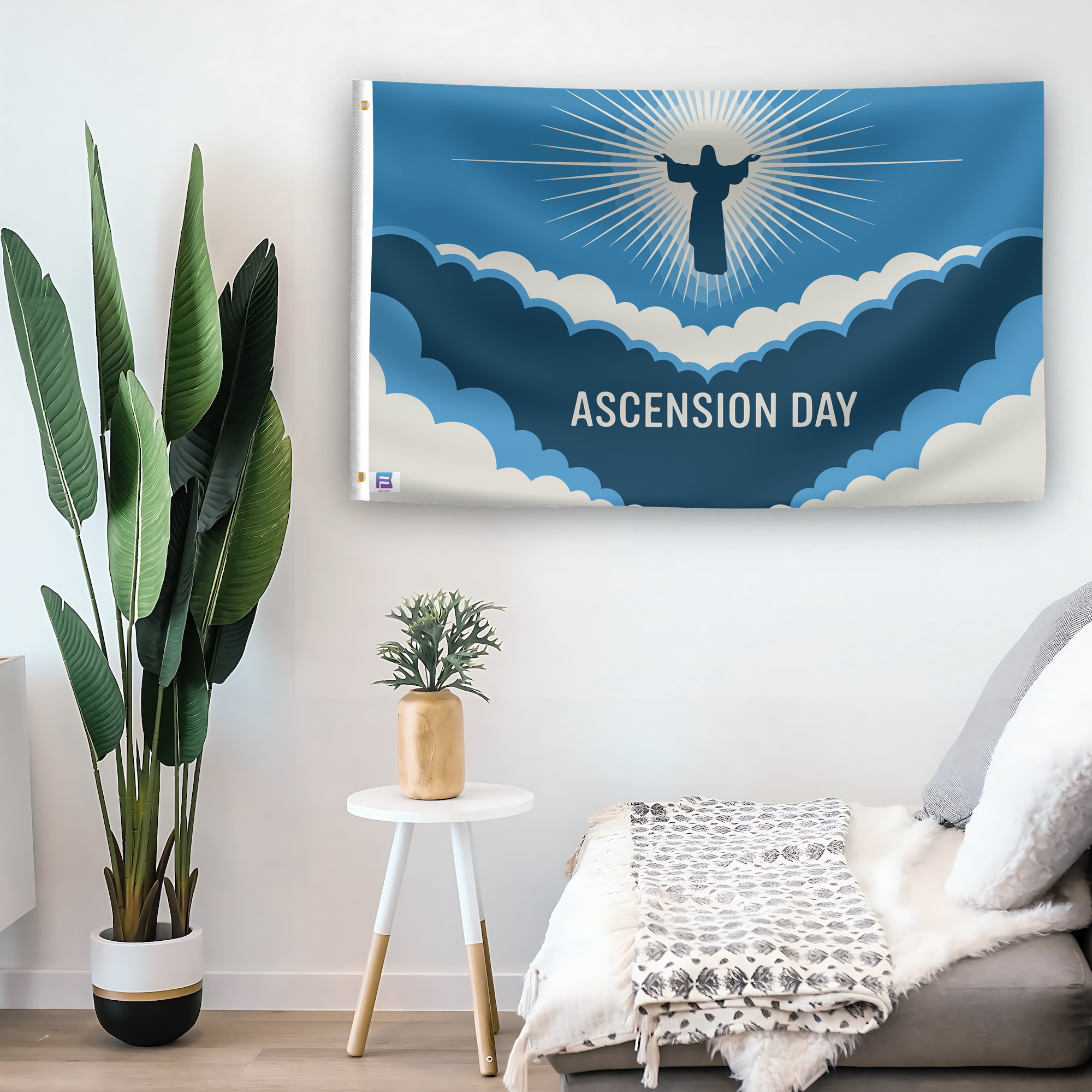 In a home setting, a flag with the saying "Ascension Day" is mounted on a white wall by a side table.