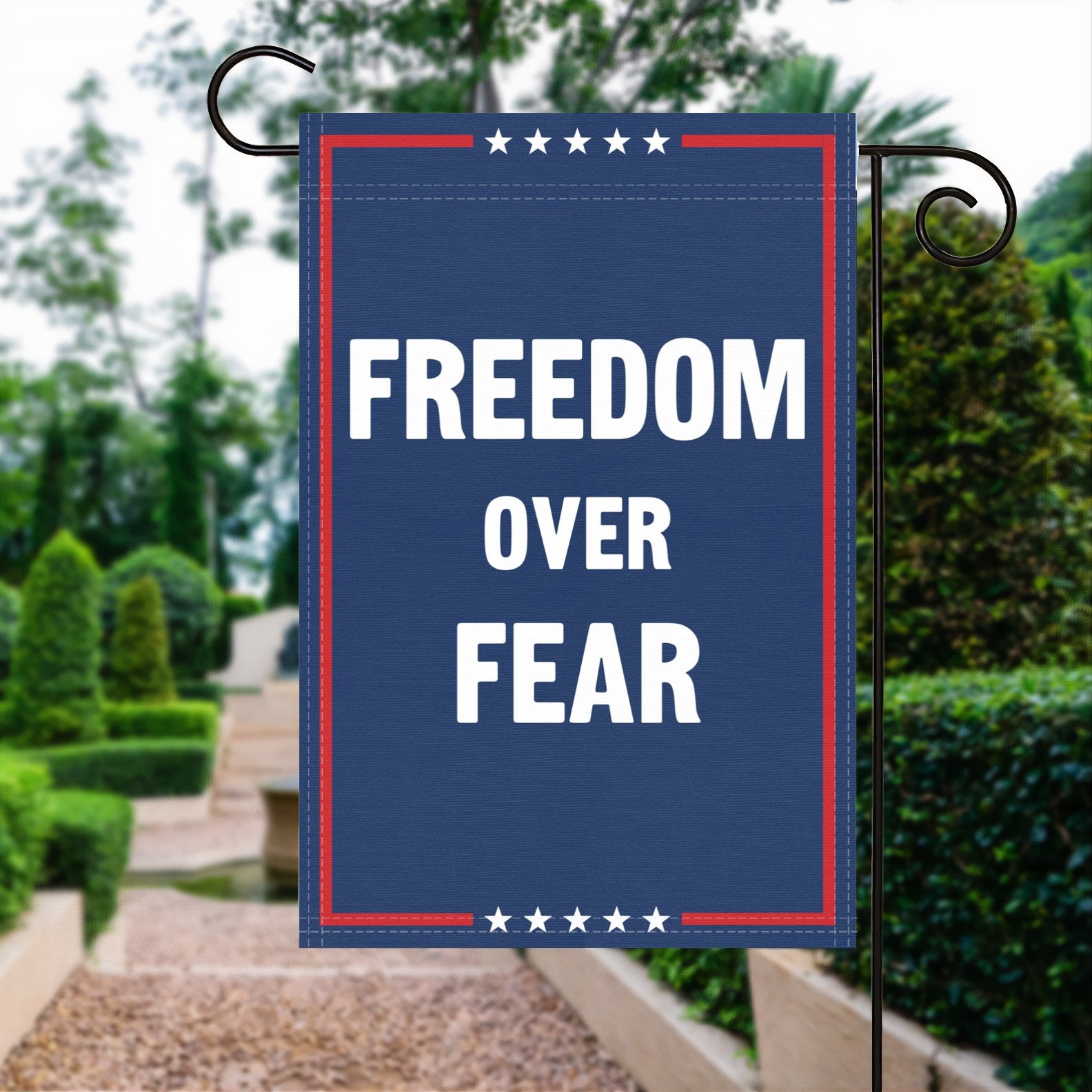 A red, white and blue political garden flag with the slogan Freedom Over Fear.