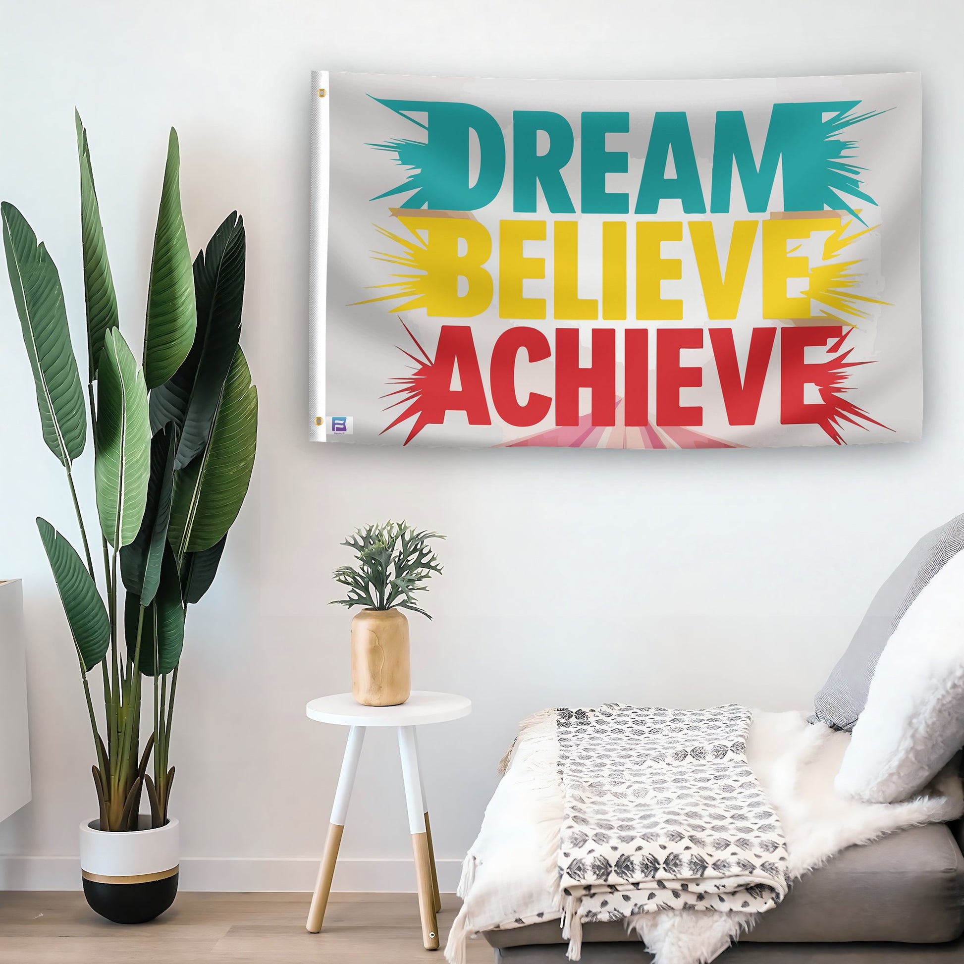 In a home setting, a flag with the saying "Dream Believe Achieve" is mounted on a white wall by a side table.