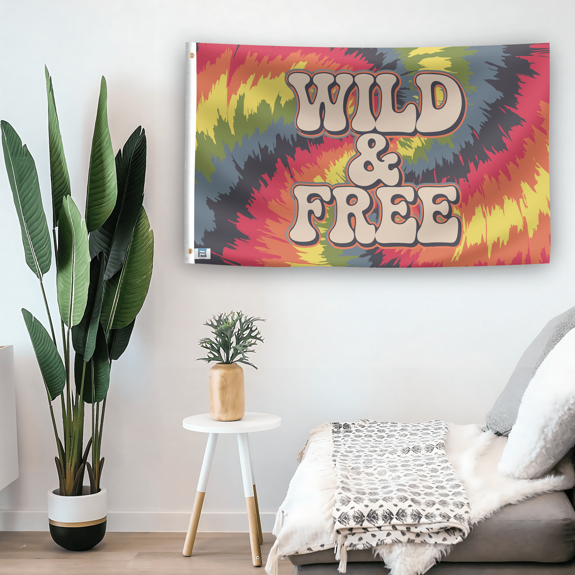 In a home setting, a flag with the saying "Wild and Free" is mounted on a white wall by a side table.