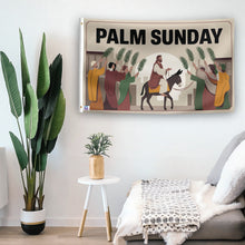 Load image into Gallery viewer, In a home setting, a flag with the saying &quot;Palm Sunday&quot; is mounted on a white wall by a side table.
