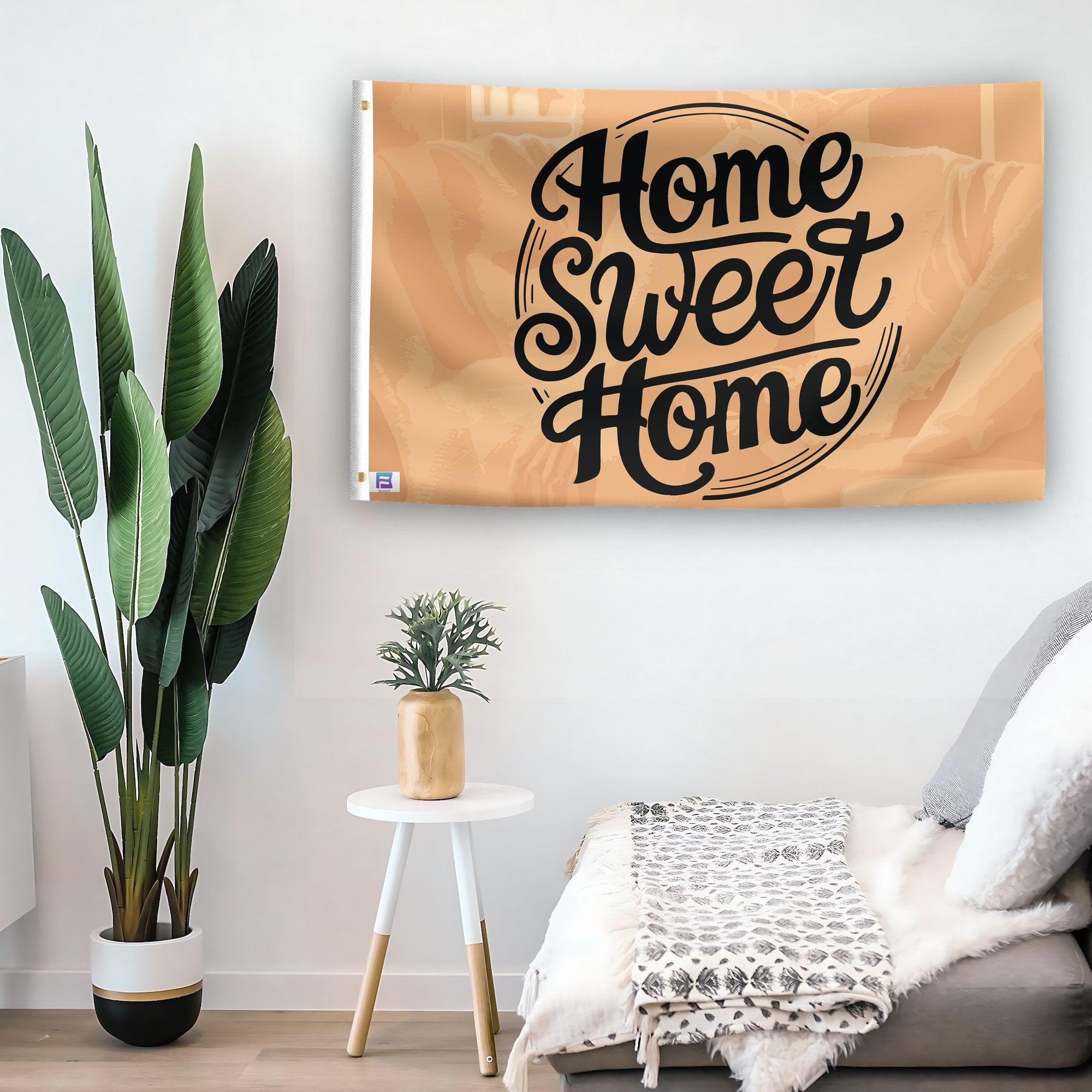 In a home setting, a flag with the saying "Home Sweet Home" is mounted on a white wall by a side table.