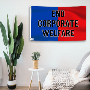 In a home setting, a blue and red flag with a political slogan is mounted on a white wall by a side table.