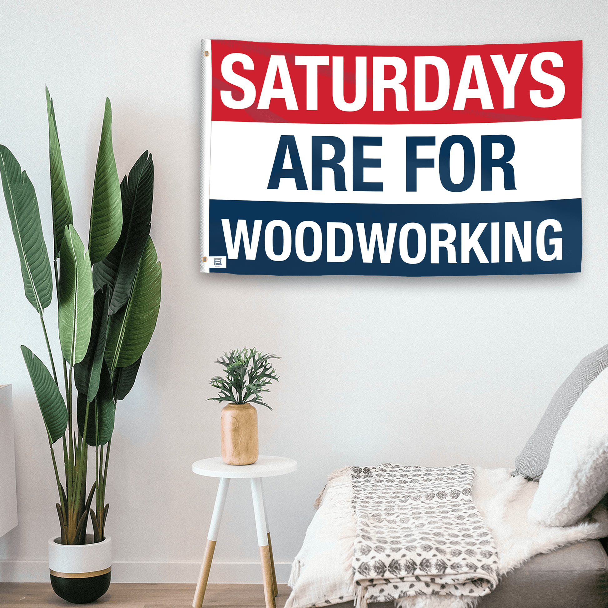 In a home setting, a flag with the saying "https://www.dropbox.com/scl/fi/wofdy5djzy0w6c6x9mj8z/saturdays-are-for-woodworking_room.png?rlkey=6xmi3cth9tby4us3h4b8pu241&raw=1" is mounted on a white wall by a side table.