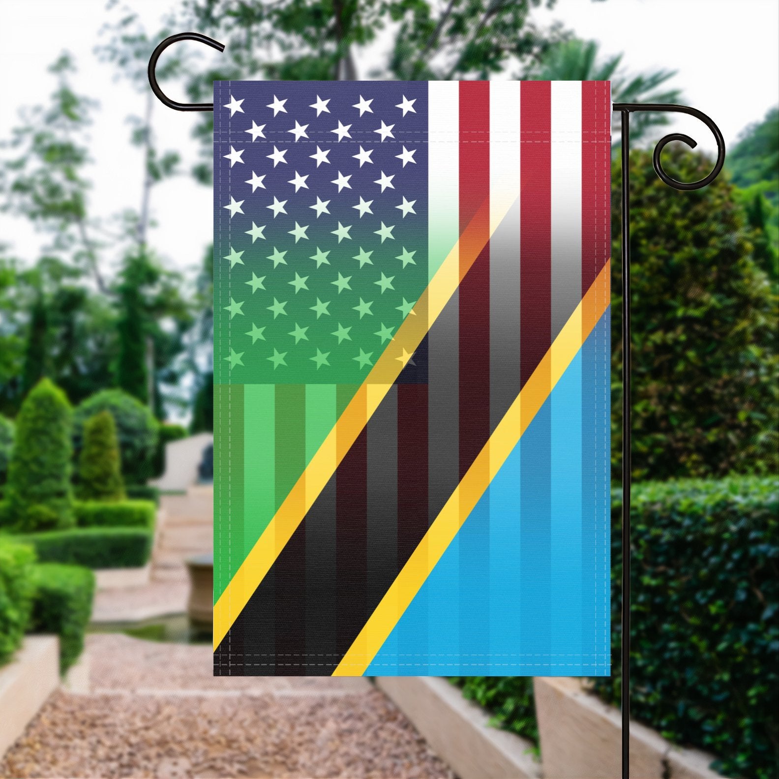 A garden flag with the Tanzanian American flag design seamlessly blended with the American flag, displayed in a garden.