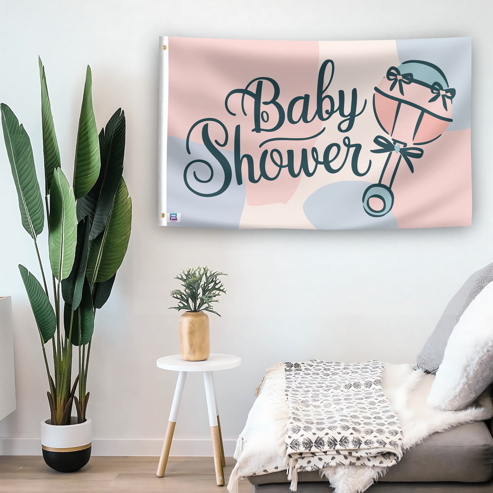 In a home setting, a flag with the saying "Baby Shower Event" is mounted on a white wall by a side table.