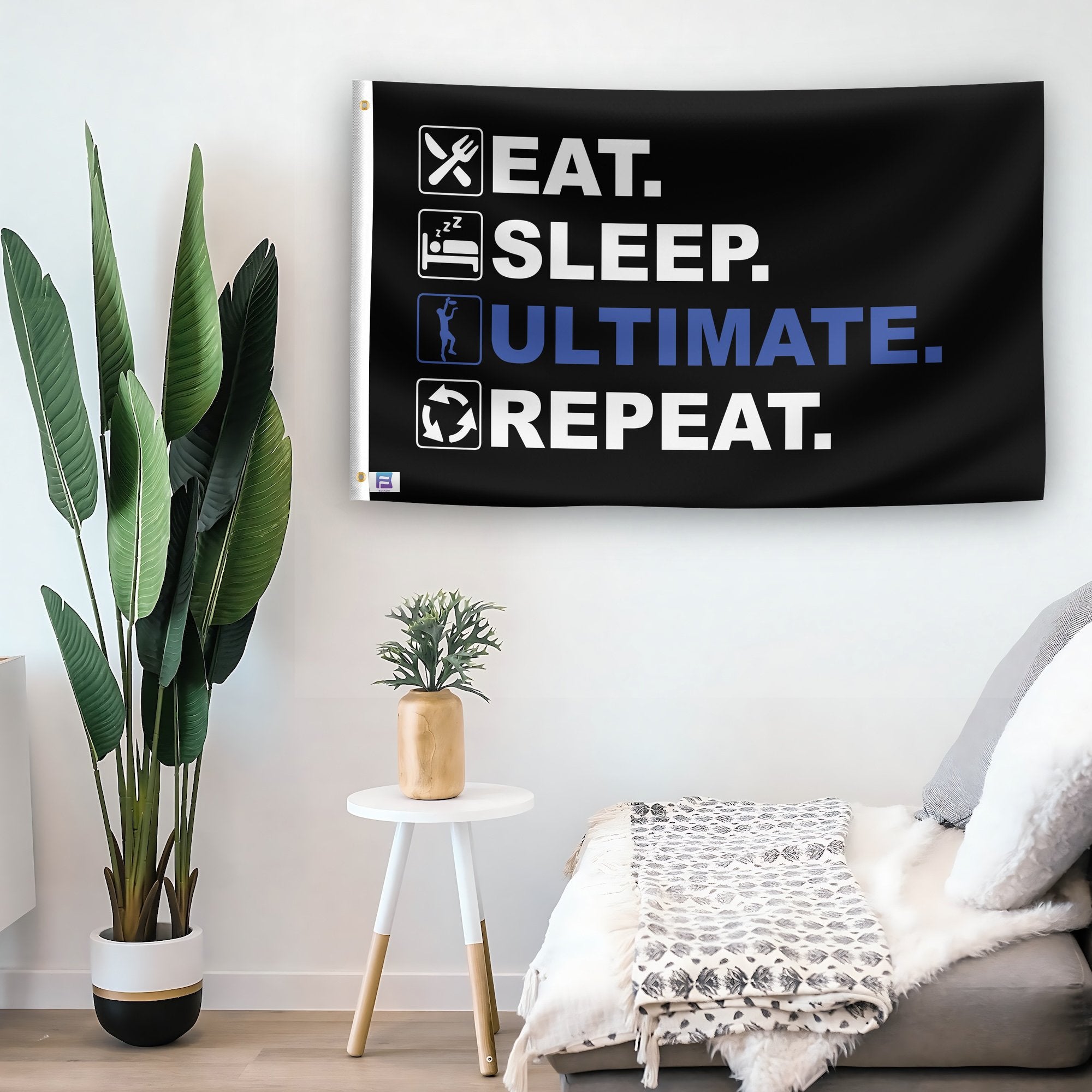 In a home setting, a flag with the saying "Eat Sleep Ultimate Frisbee Repeat" is mounted on a white wall by a side table.