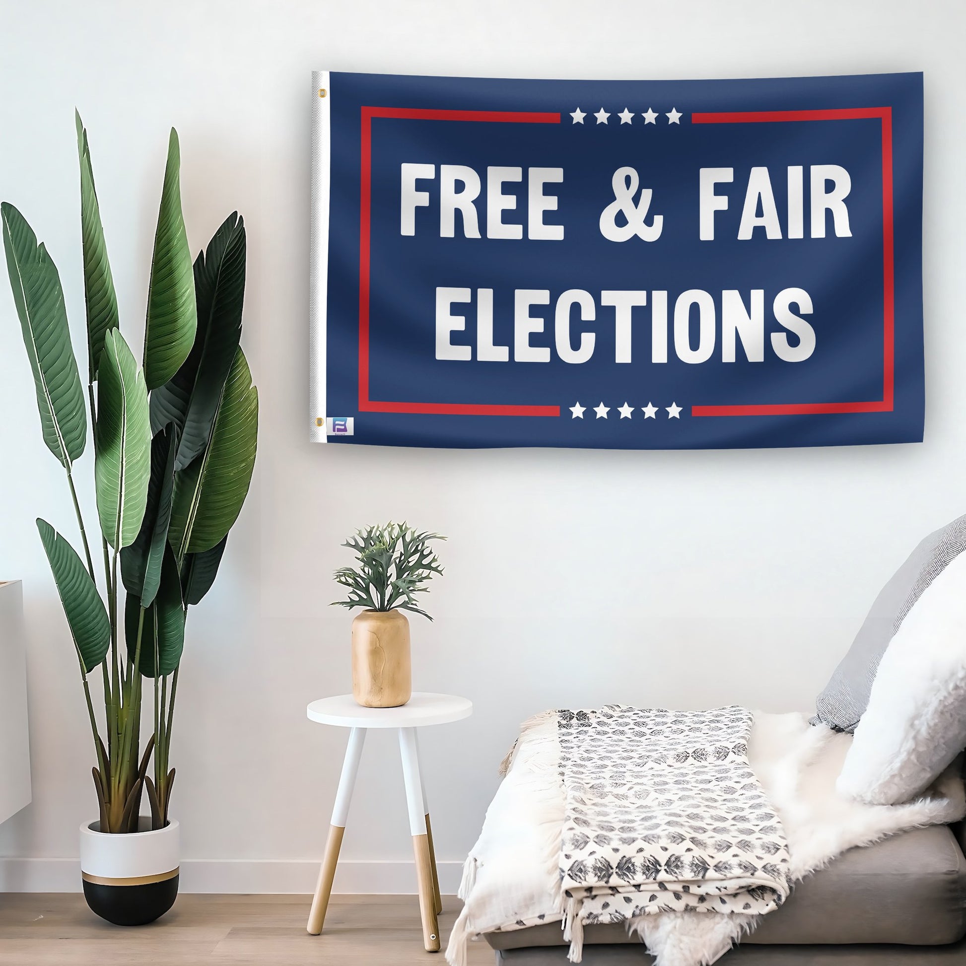 In a home setting, a flag with the saying "Free And Fair Elections Political" is mounted on a white wall by a side table.