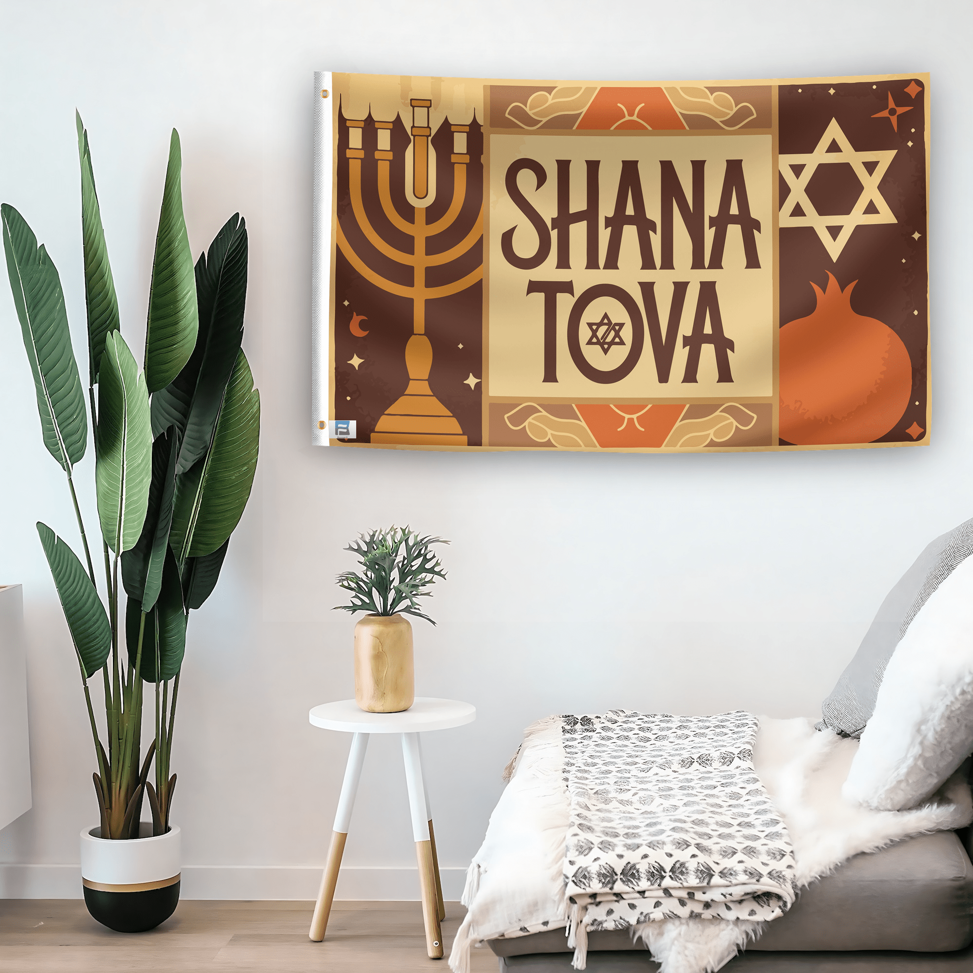 In a home setting, a flag with the saying "Shana Tova" is mounted on a white wall by a side table.