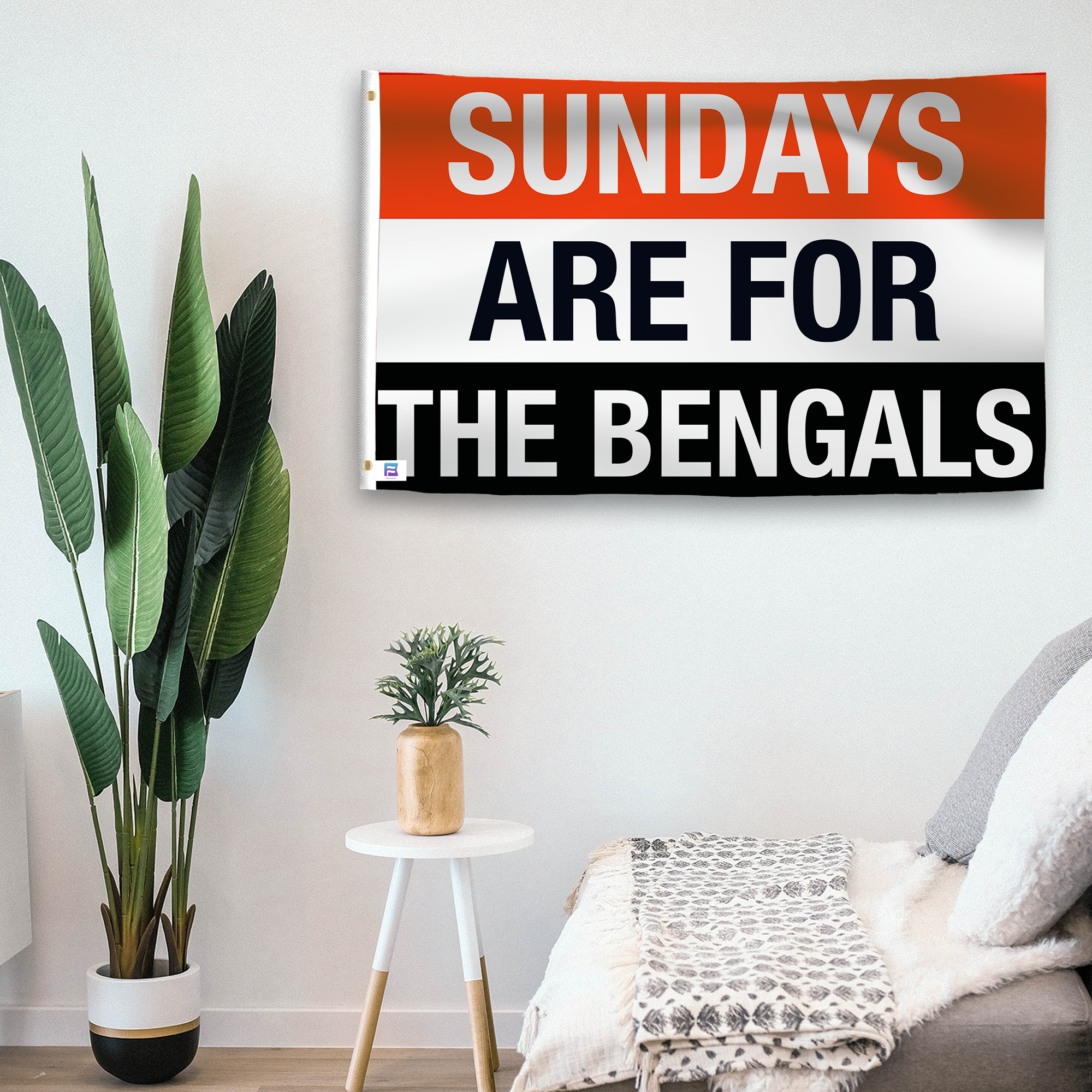 In a home setting, a flag with the saying "https://www.dropbox.com/scl/fi/xmwzxd2yangeuohvb50c6/sundays-are-for-the-bengals_room.png?rlkey=rufyac9gfuwufij6e4jjdzk34&raw=1" is mounted on a white wall by a side table.