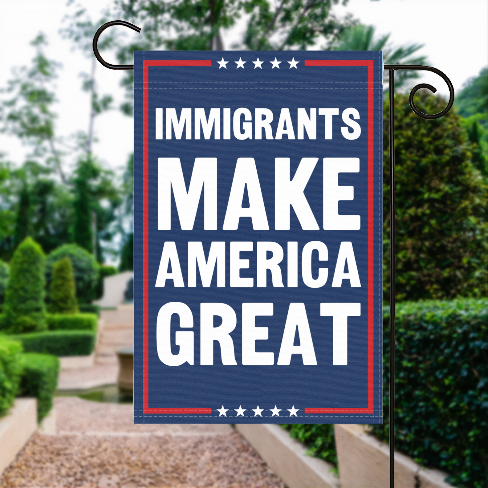 A red, white and blue political garden flag with the slogan Immigrants Make America Great.