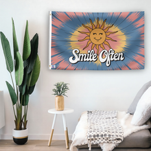 Load image into Gallery viewer, In a home setting, a flag with the saying &quot;Smile Often 70s Style&quot; is mounted on a white wall by a side table.
