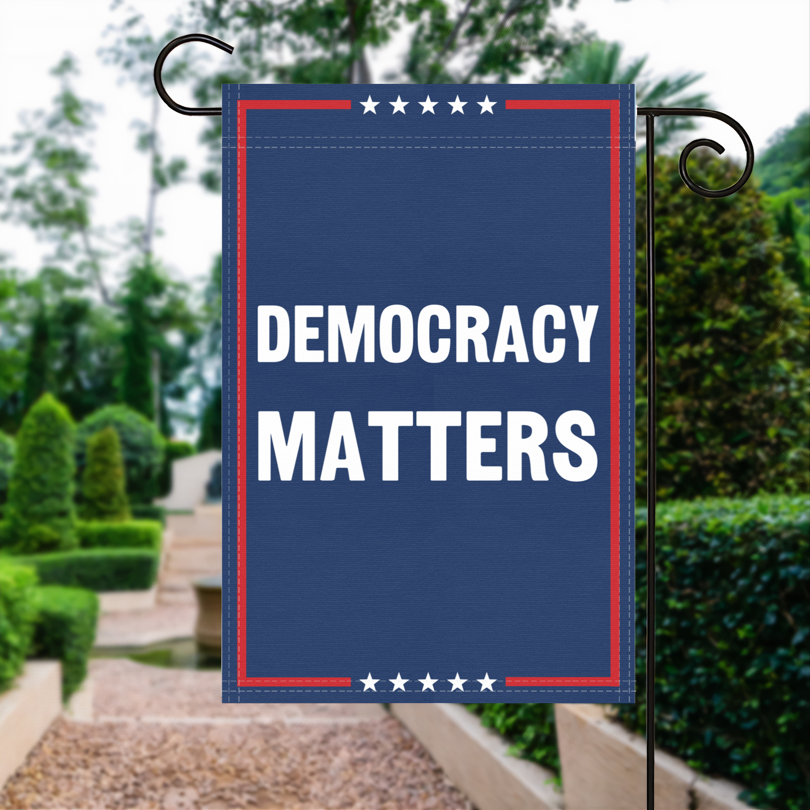 A red, white and blue political garden flag with the slogan Democracy Matters.