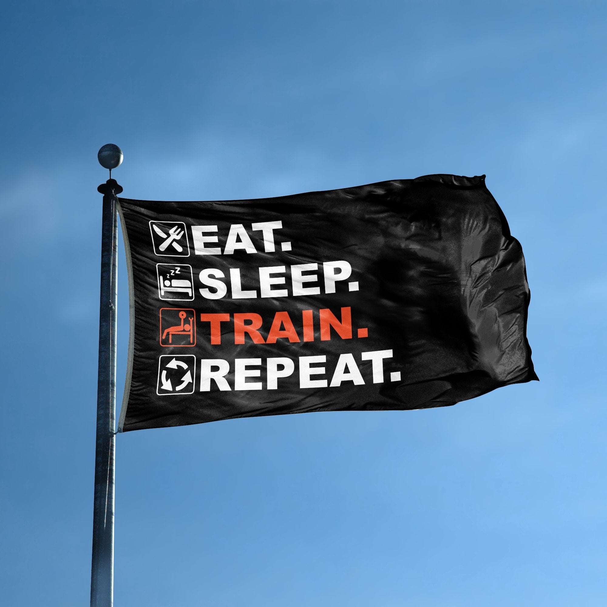 A flag with the saying "Eat Sleep Train Repeat" displayed on a high pole, with a black, white and themed color scheme.