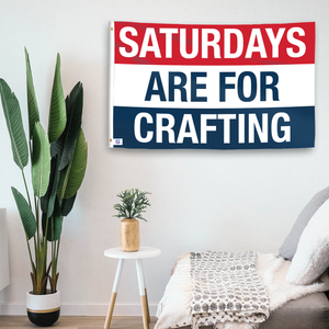 In a home setting, a flag with the saying "https://www.dropbox.com/scl/fi/h1drkdbh86cuqoxdn7fni/saturdays-are-for-crafting_room.png?rlkey=zhp3h0wxvkzklmvodvpepqz0p&raw=1" is mounted on a white wall by a side table.