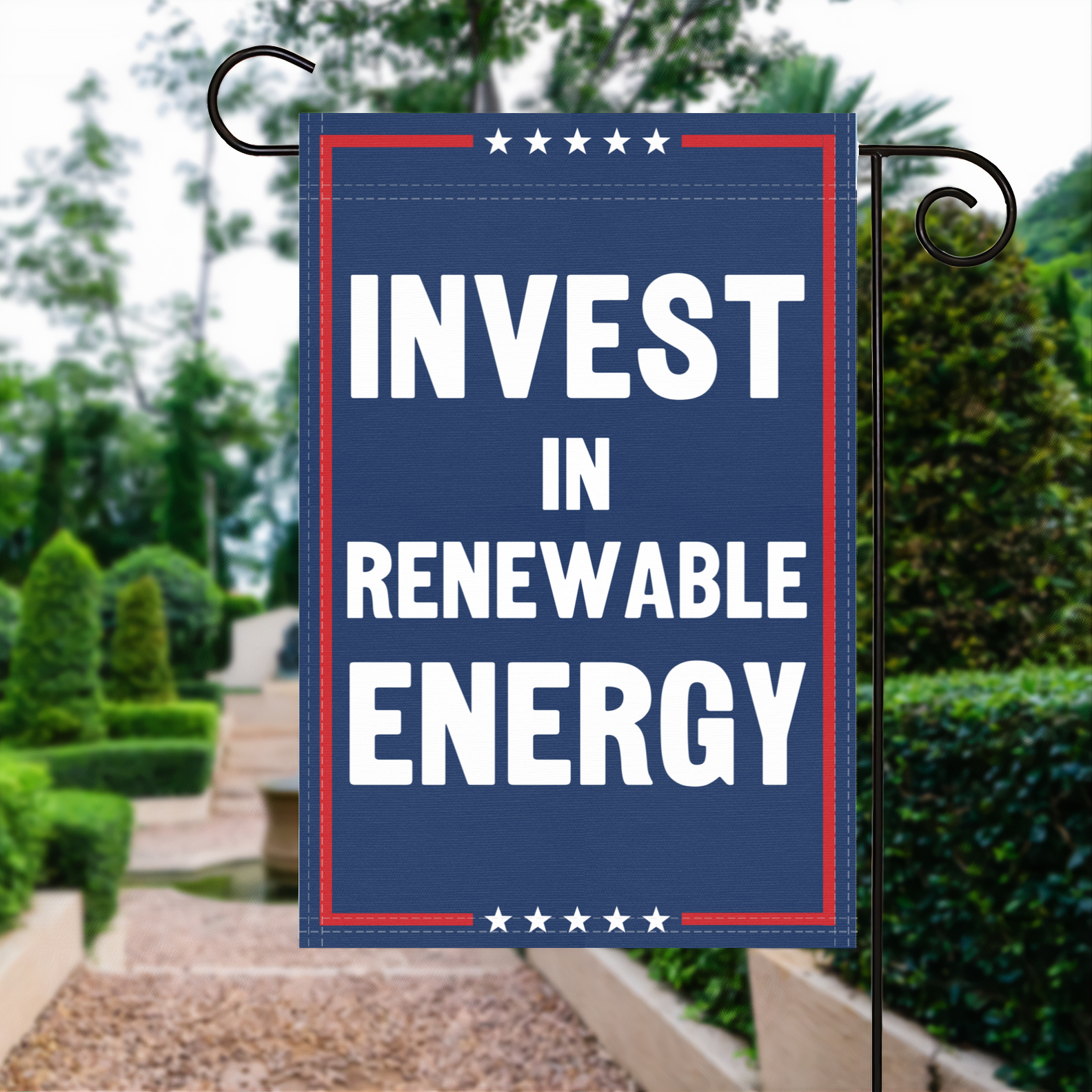 A red, white and blue political garden flag with the slogan Invest In Renewable Energy.