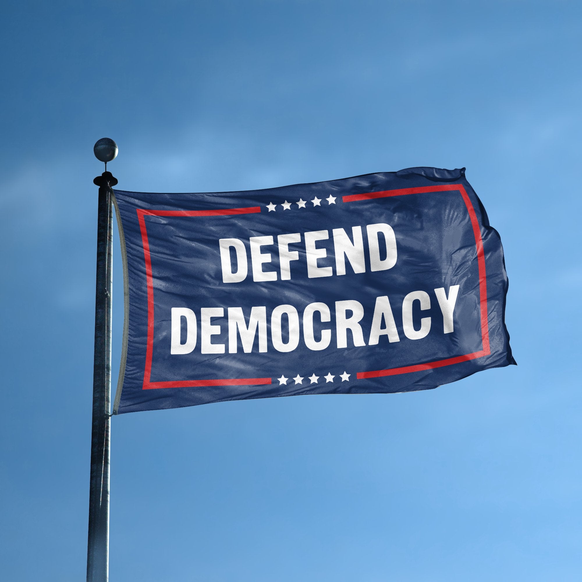 A flag with the saying "Defend Democracy Political" displayed on a high pole, with a red, white, and blue color scheme.