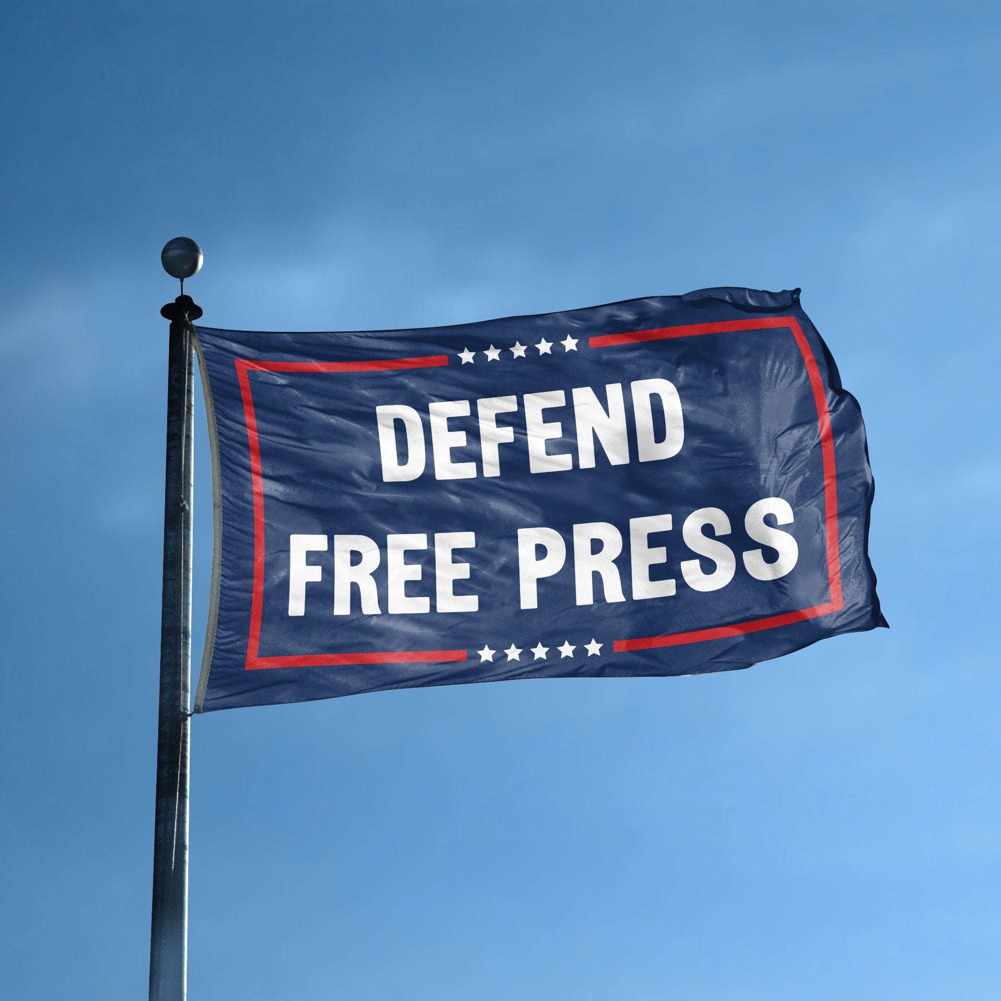 A flag with the saying "Defend Free Press Political" displayed on a high pole, with a red, white, and blue color scheme.