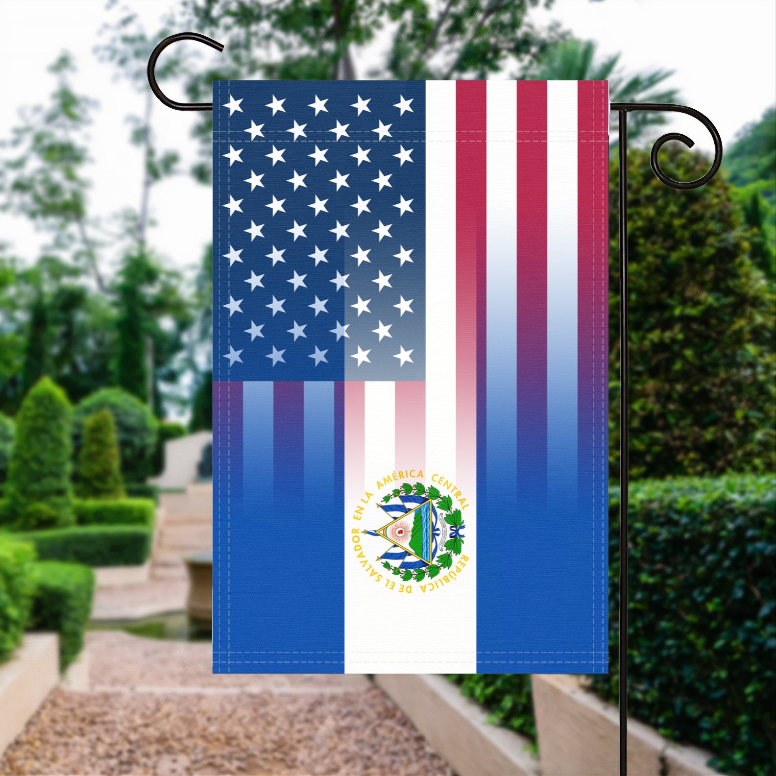 A garden flag with the Salvadoran American flag design seamlessly blended with the American flag, displayed in a garden.