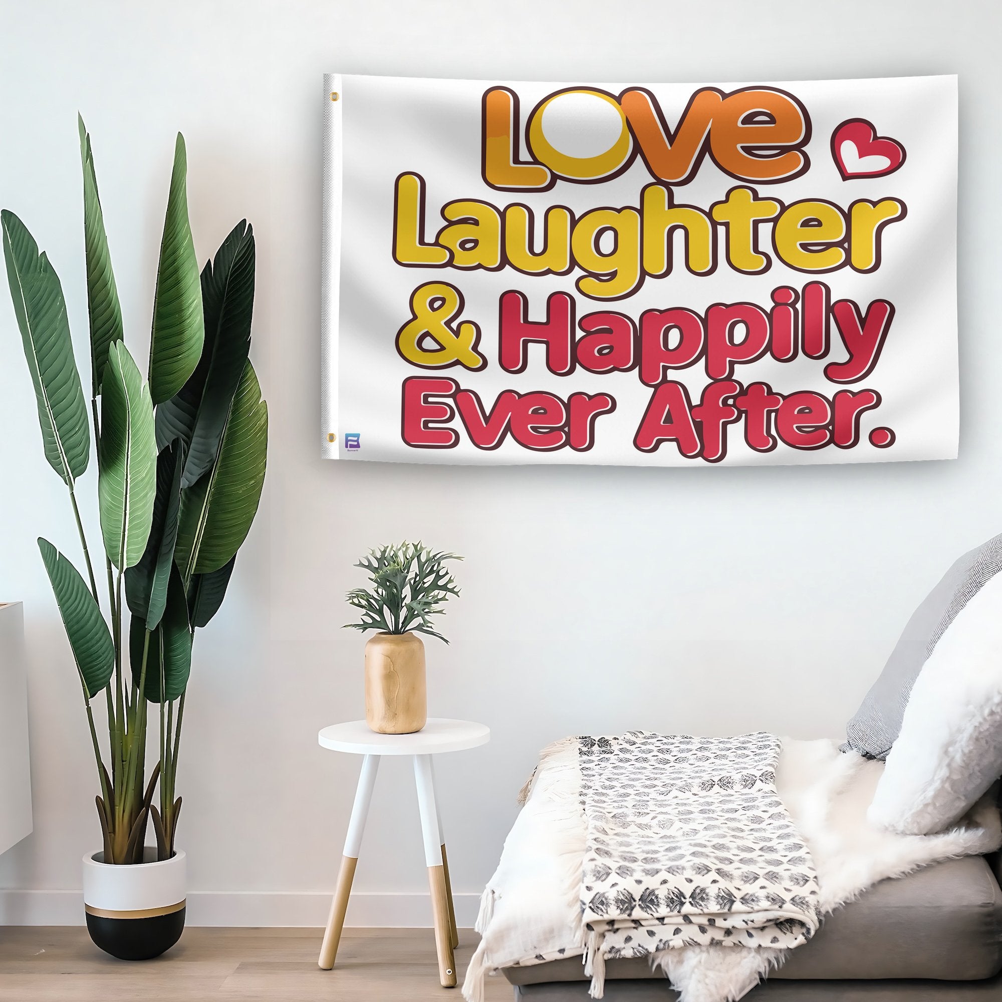 In a home setting, a flag with the saying "Love Laughter & Happily Ever After" is mounted on a white wall by a side table.