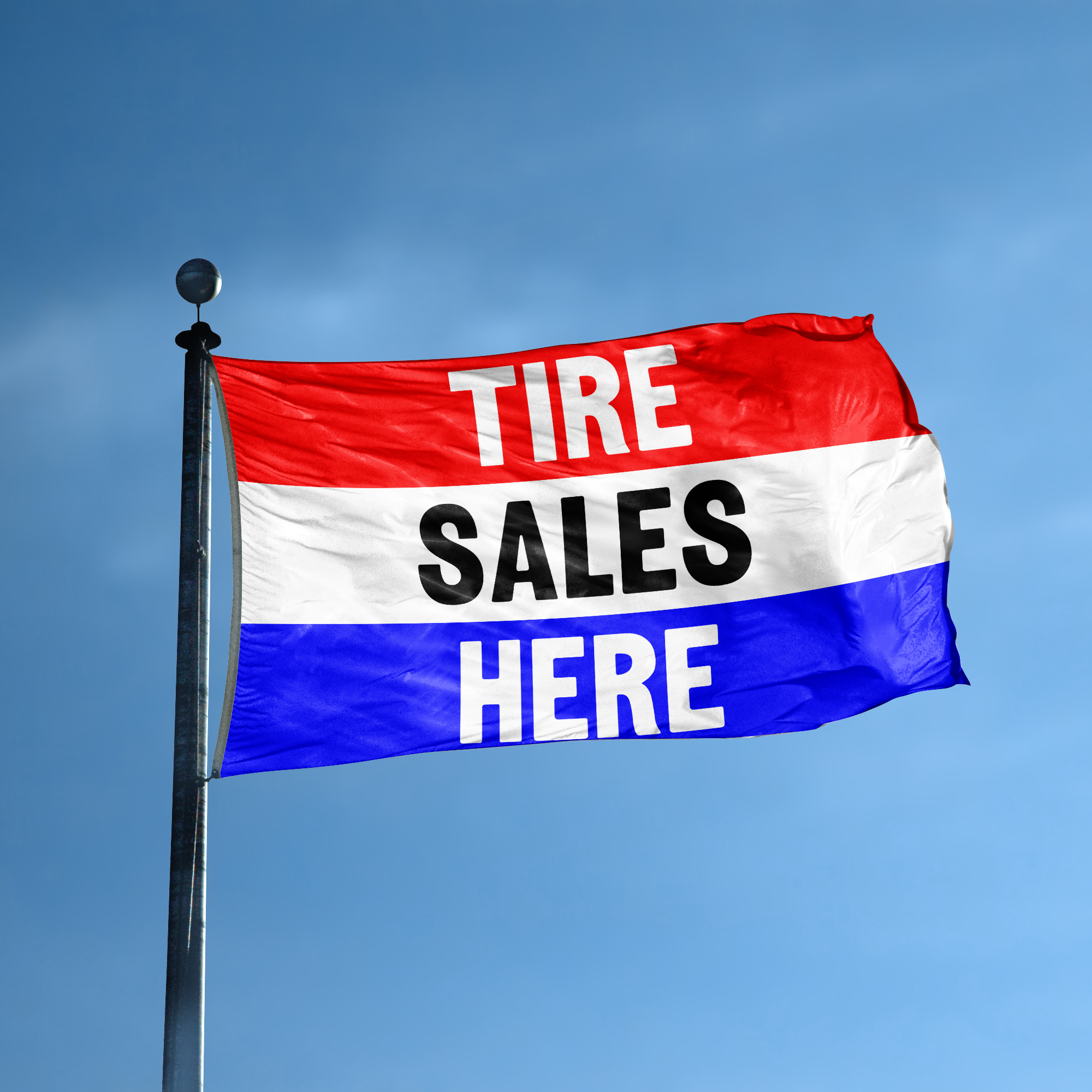 A business banner with the saying "Tire Sales Here" displayed on a high pole, with a red, white, and blue color scheme.