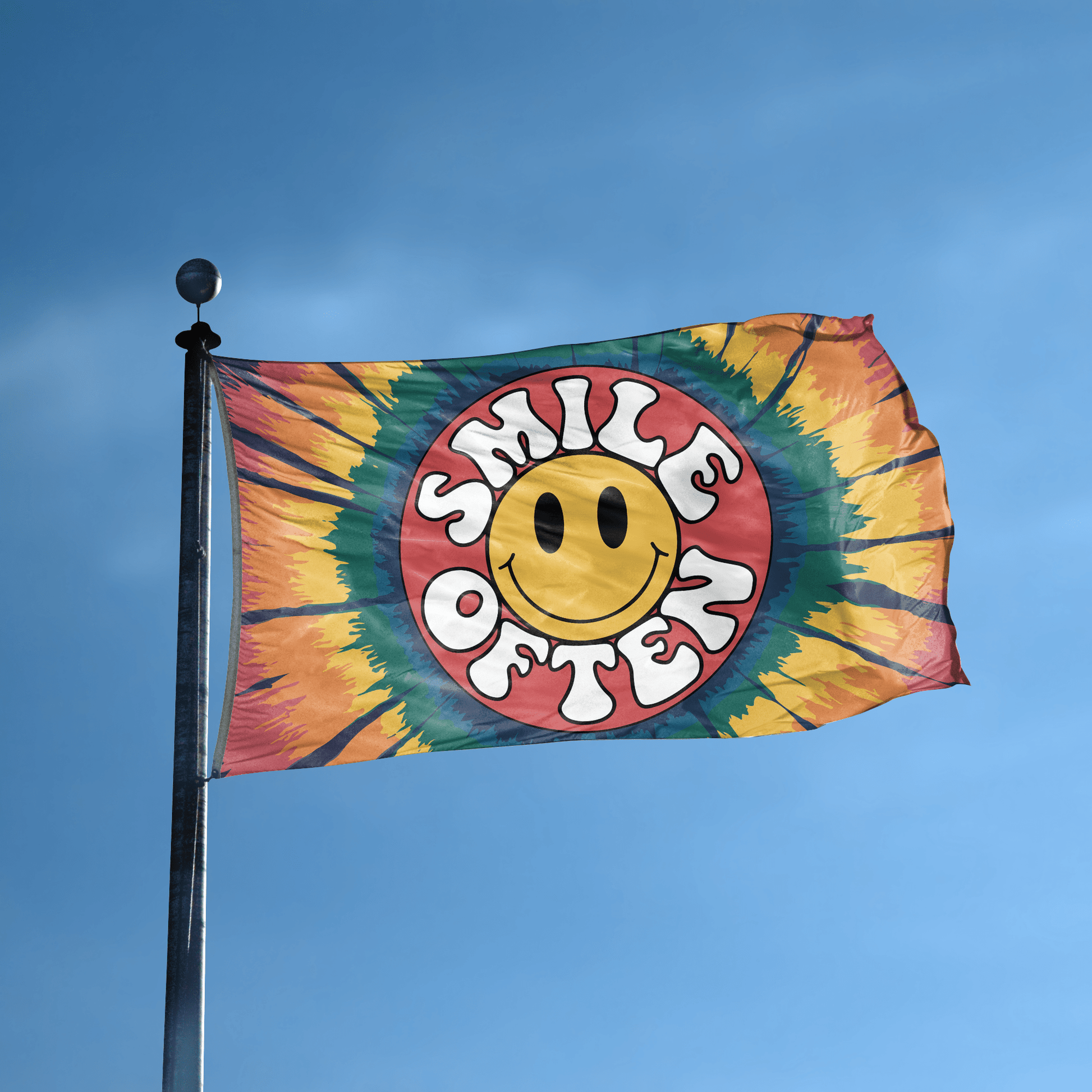 A flag with the saying "Smile Often" displayed on a high pole, with a tie dye style color scheme.