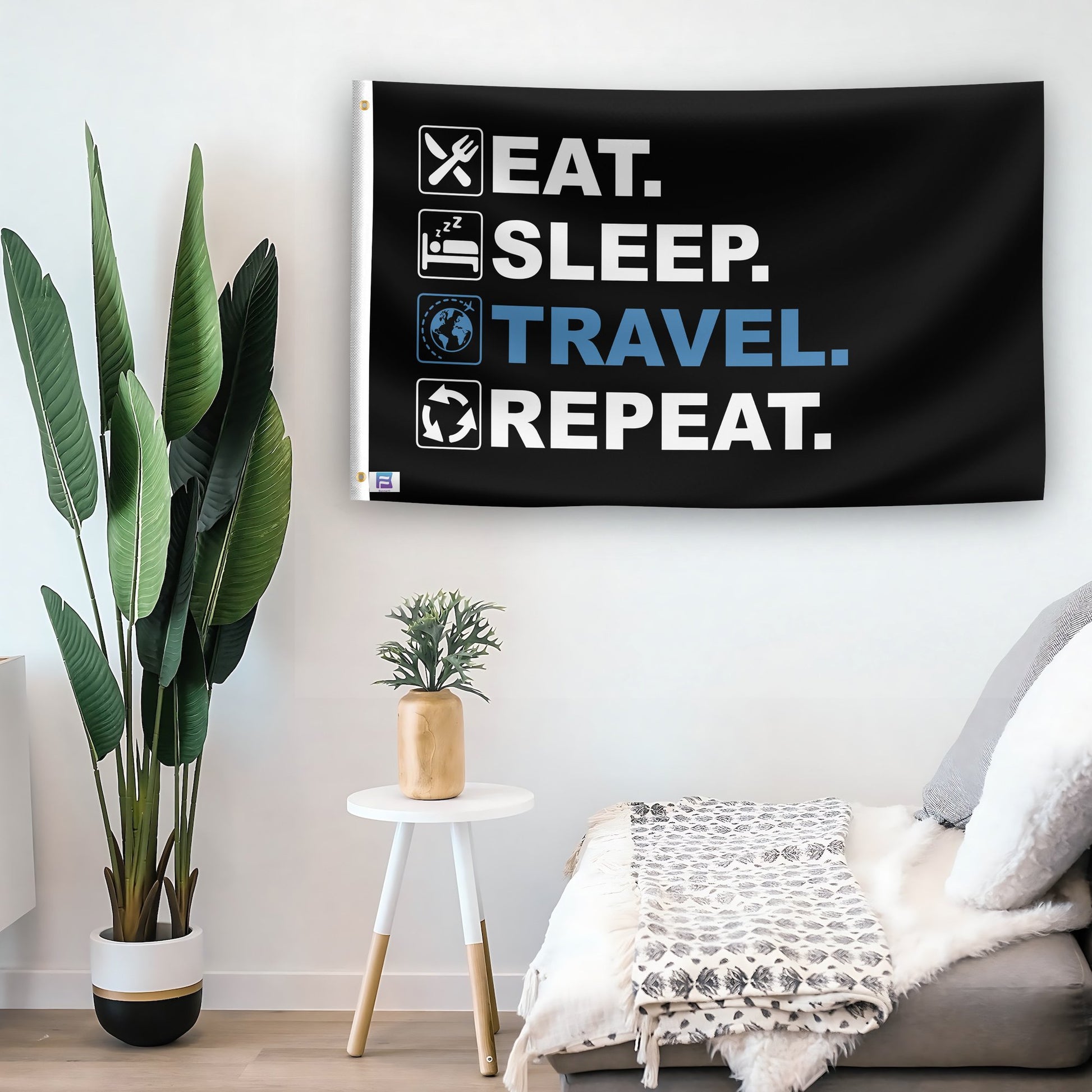 In a home setting, a flag with the saying "Eat Sleep Travel Repeat" is mounted on a white wall by a side table.