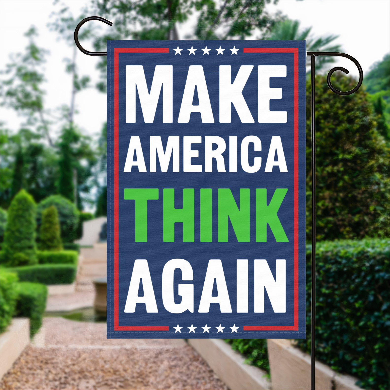 A red, white and blue political garden flag with the slogan Make America Think Again.