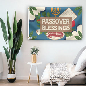 In a home setting, a flag with the saying "Passover Blessings" is mounted on a white wall by a side table.