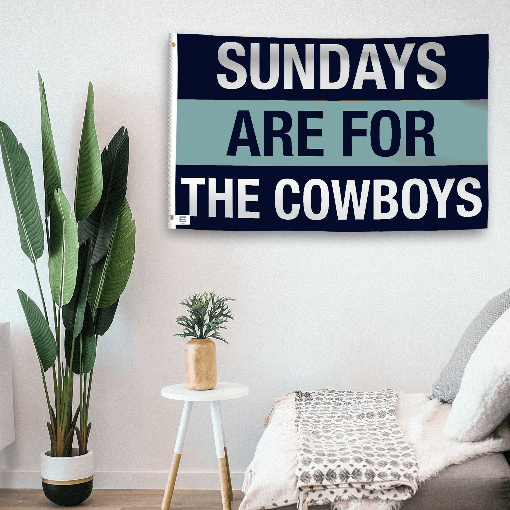 In a home setting, a flag with the saying "https://www.dropbox.com/scl/fi/80p2ximm9ehhz2lgtwk99/sundays-are-for-the-cowboys_room.png?rlkey=vc2178z2eyaqmnci3zpd63r4r&raw=1" is mounted on a white wall by a side table.