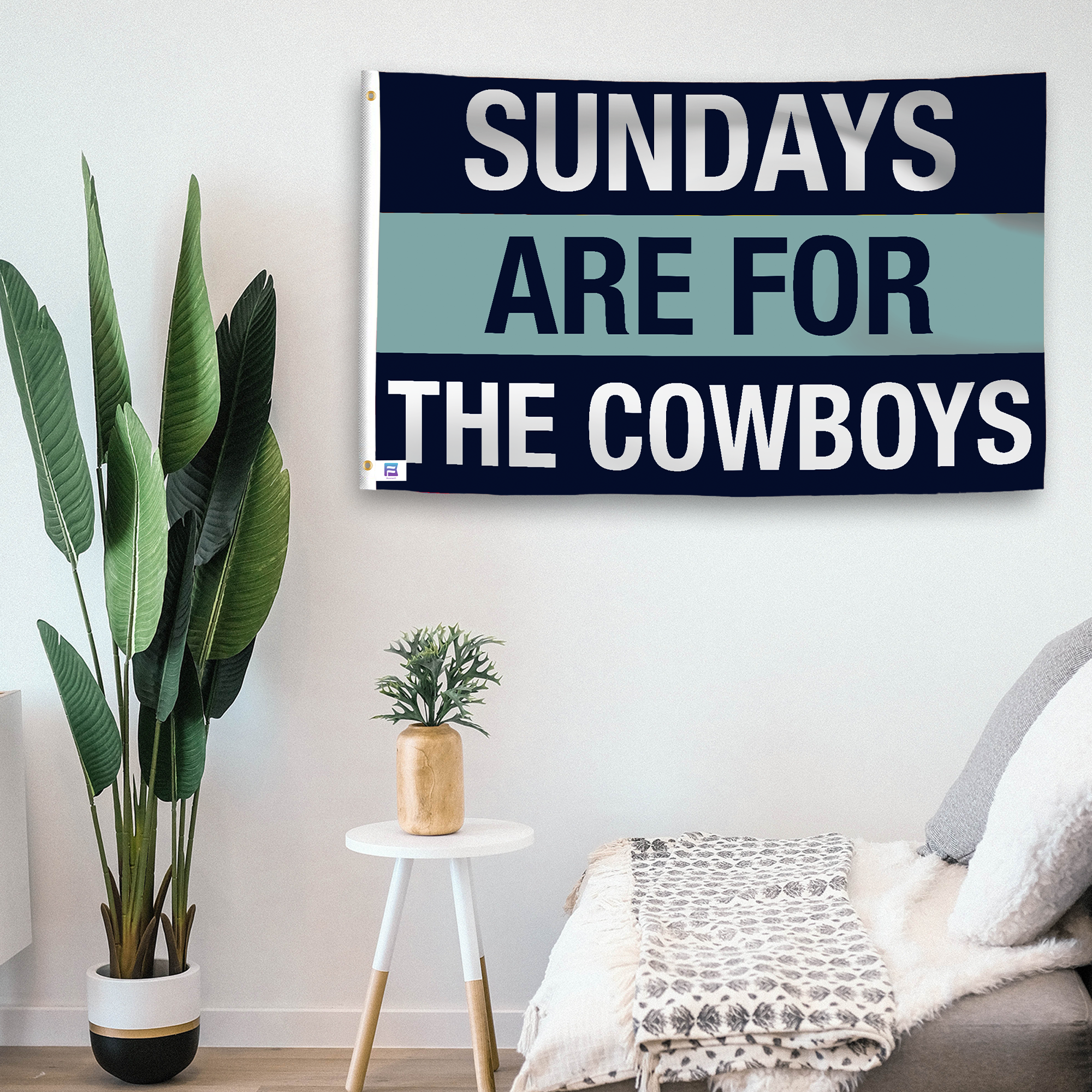 In a home setting, a flag with the saying "https://www.dropbox.com/scl/fi/80p2ximm9ehhz2lgtwk99/sundays-are-for-the-cowboys_room.png?rlkey=vc2178z2eyaqmnci3zpd63r4r&raw=1" is mounted on a white wall by a side table.