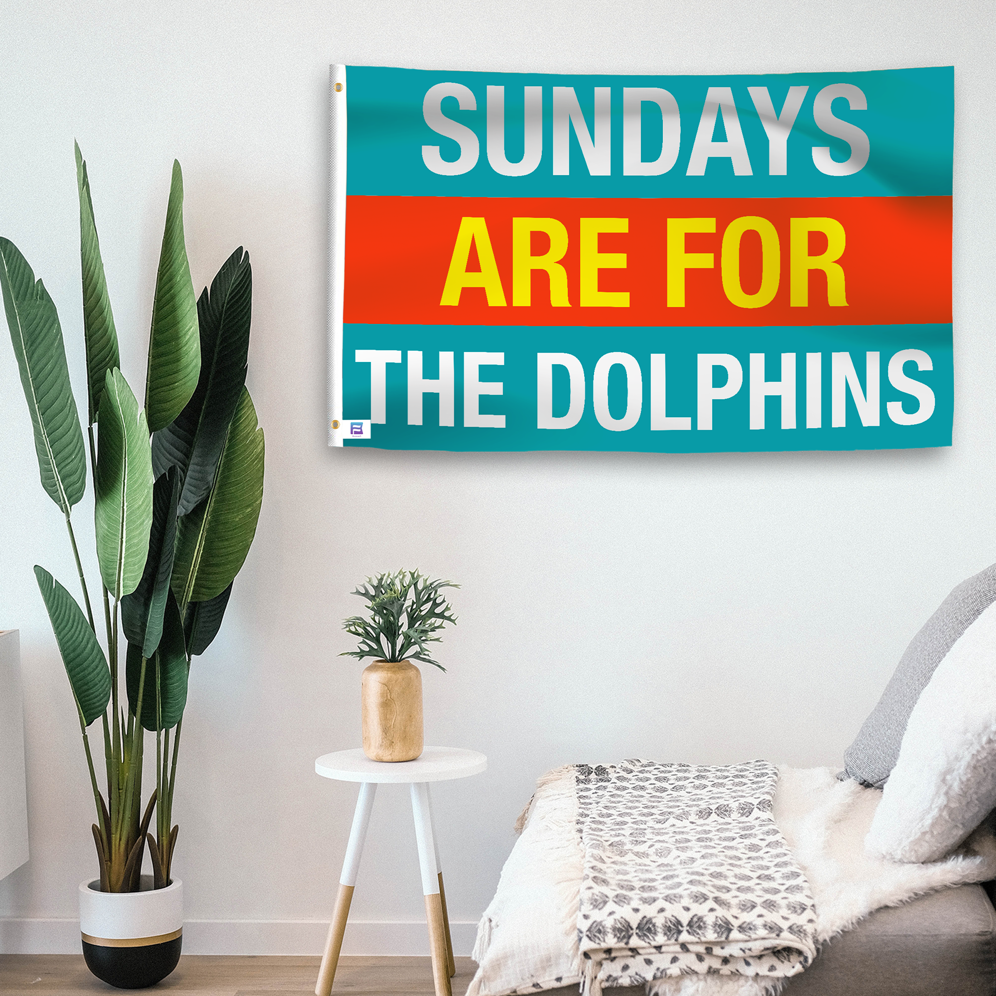 In a home setting, a flag with the saying "https://www.dropbox.com/scl/fi/1i4tqujj3gggl1p6jv9q0/sundays-are-for-the-dolphins_room.png?rlkey=1b3zuil7zuw29ya8te679mwyi&raw=1" is mounted on a white wall by a side table.