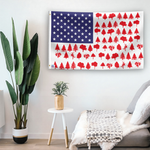 Load image into Gallery viewer, In a home setting, an american flag with the theme &quot;Tree Stripes American&quot; is mounted on a white wall by a side table.
