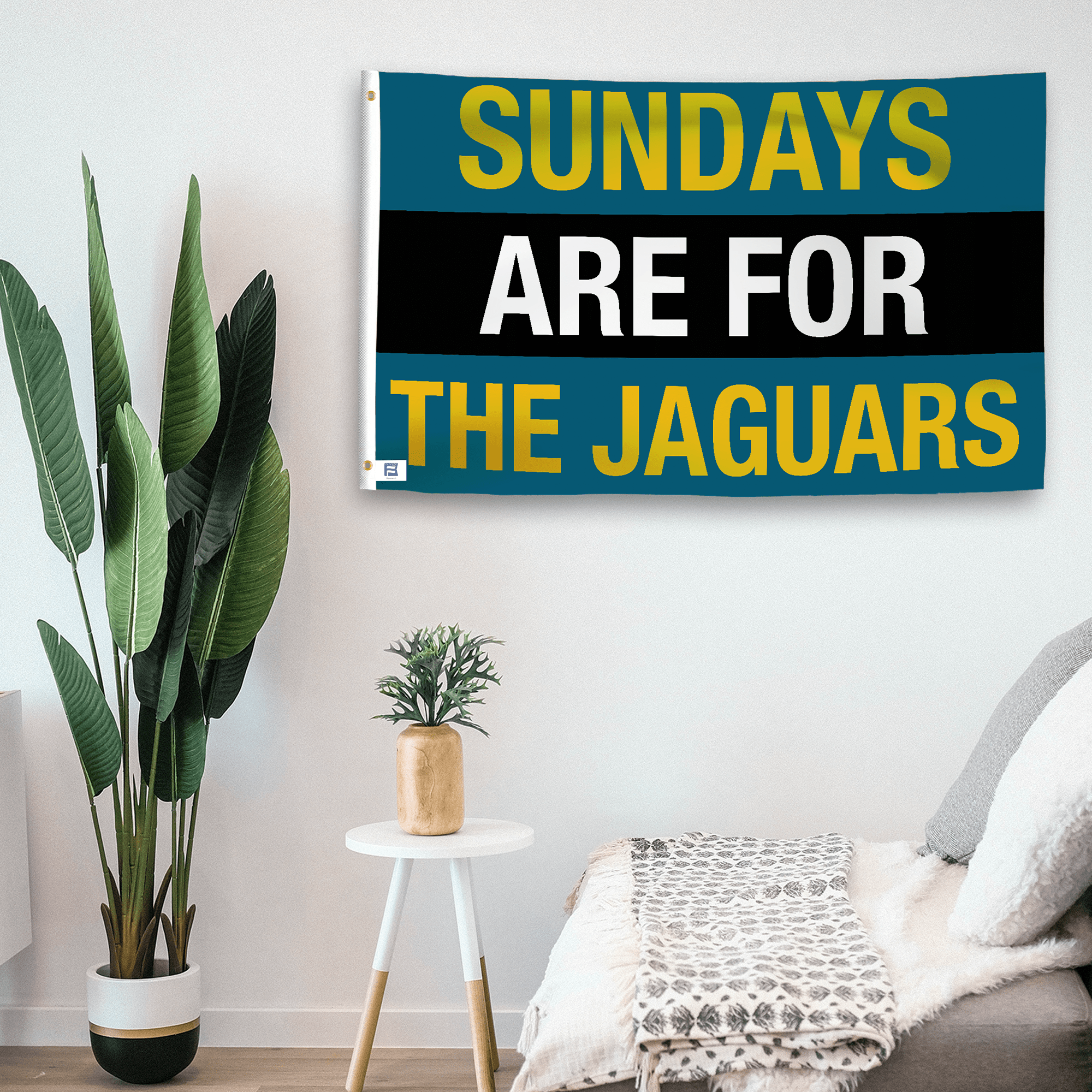 In a home setting, a flag with the saying "https://www.dropbox.com/scl/fi/qitdbpa0mow2n69ef4kr3/sundays-are-for-the-jaguars_room.png?rlkey=swsr4l3lmsnqzyc0o1gllhvg0&raw=1" is mounted on a white wall by a side table.