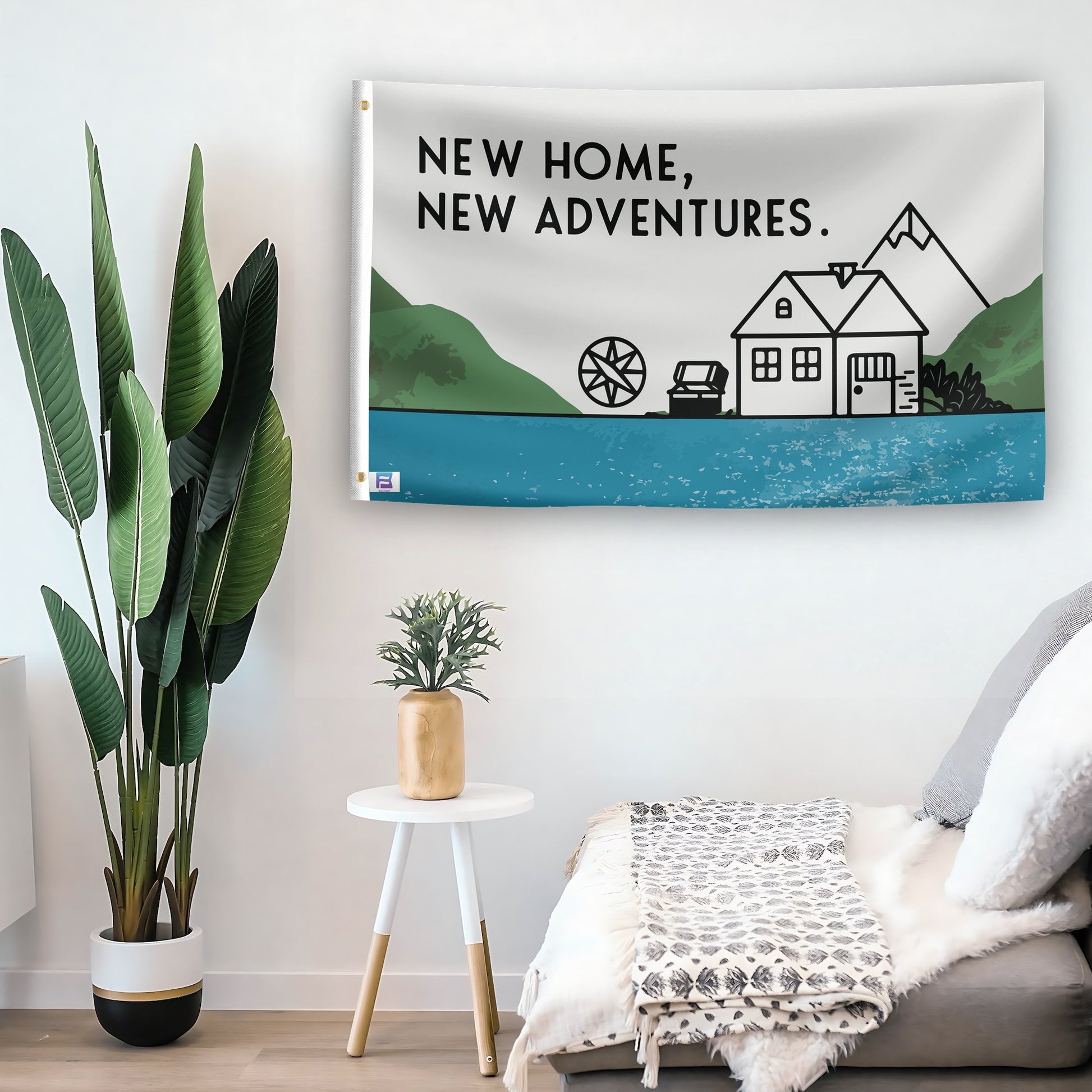 In a home setting, a flag with the saying "New Home New Adventures House" is mounted on a white wall by a side table.