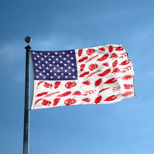 An american flag with the red stripes changed to match the theme "Tree Leaf Stripes American" displayed on a high pole.