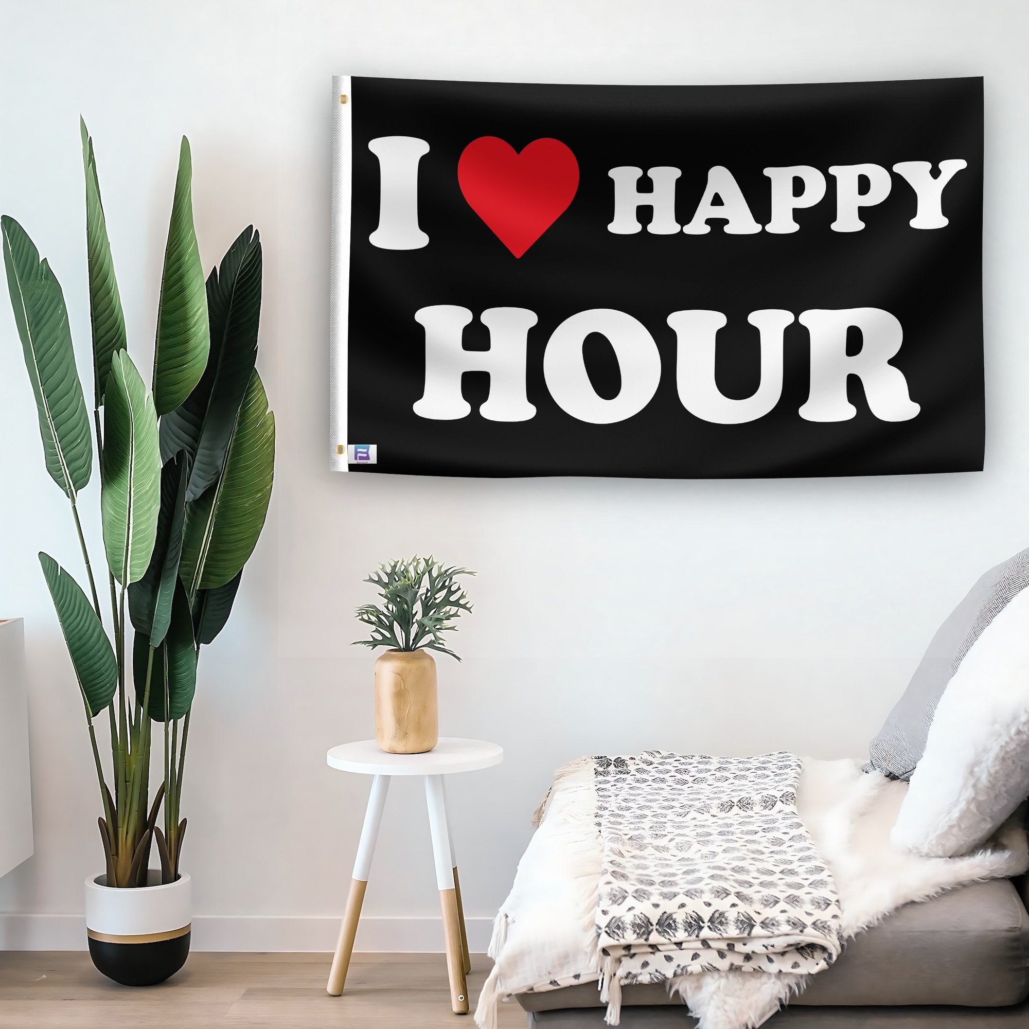 In a home setting, a flag with the saying "I Love Happy Hour" is mounted on a white wall by a side table.