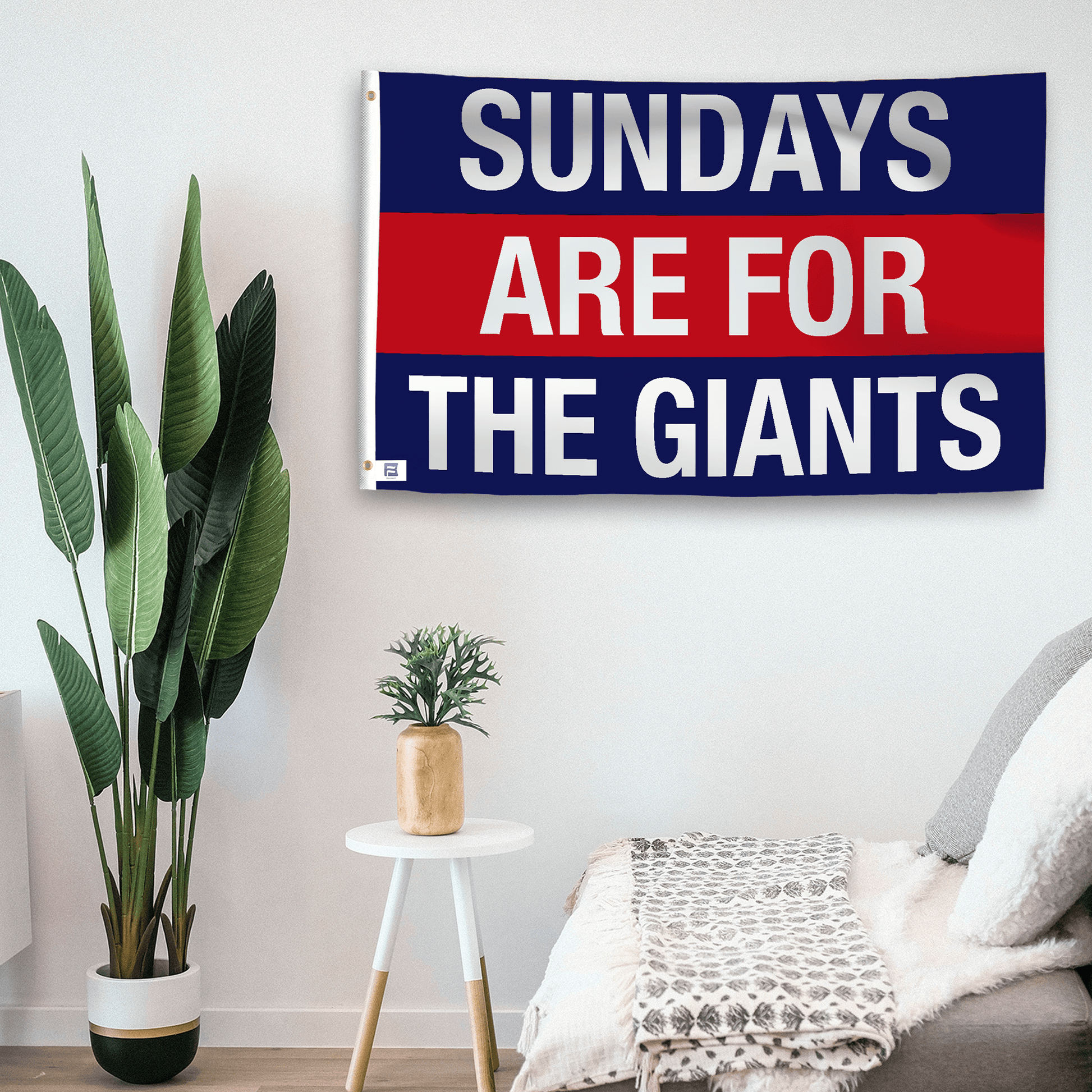 In a home setting, a flag with the saying "https://www.dropbox.com/scl/fi/smjx8jgx5cvmwb4q0tuj9/sundays-are-for-the-giants_room.png?rlkey=hu4pl4se1iqwvtis2ga5yzzky&raw=1" is mounted on a white wall by a side table.