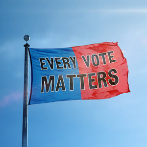 A flag containing a political slogan displayed on a high pole, featuring a patriotic red and blue background.