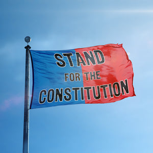 A flag containing a political slogan displayed on a high pole, featuring a patriotic red and blue background.