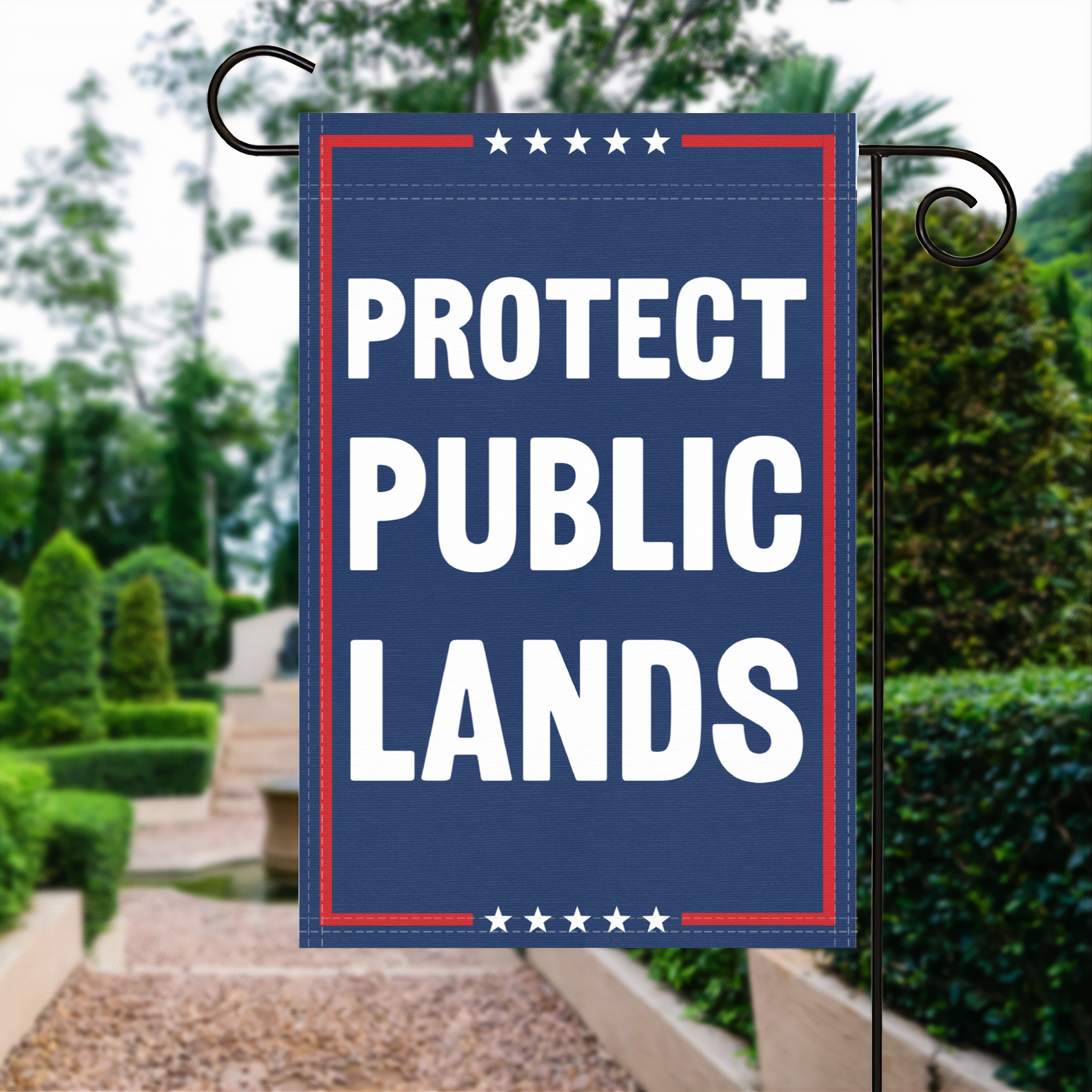 A red, white and blue political garden flag with the slogan Protect Public Lands.