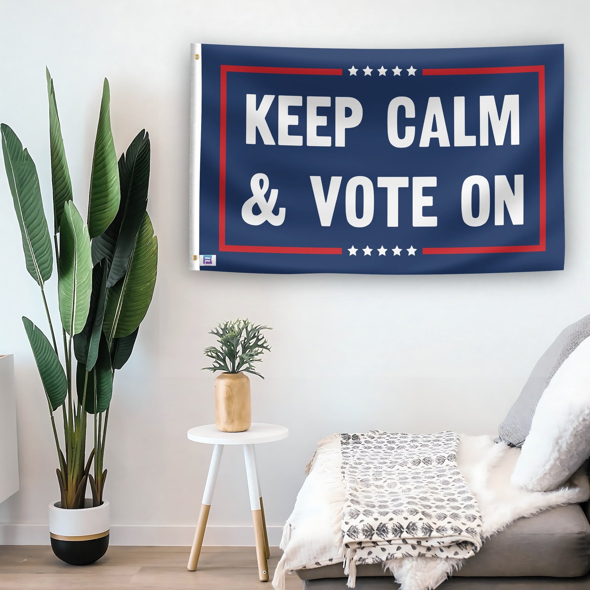 In a home setting, a flag with the saying "Keep Calm And Vote On Political" is mounted on a white wall by a side table.